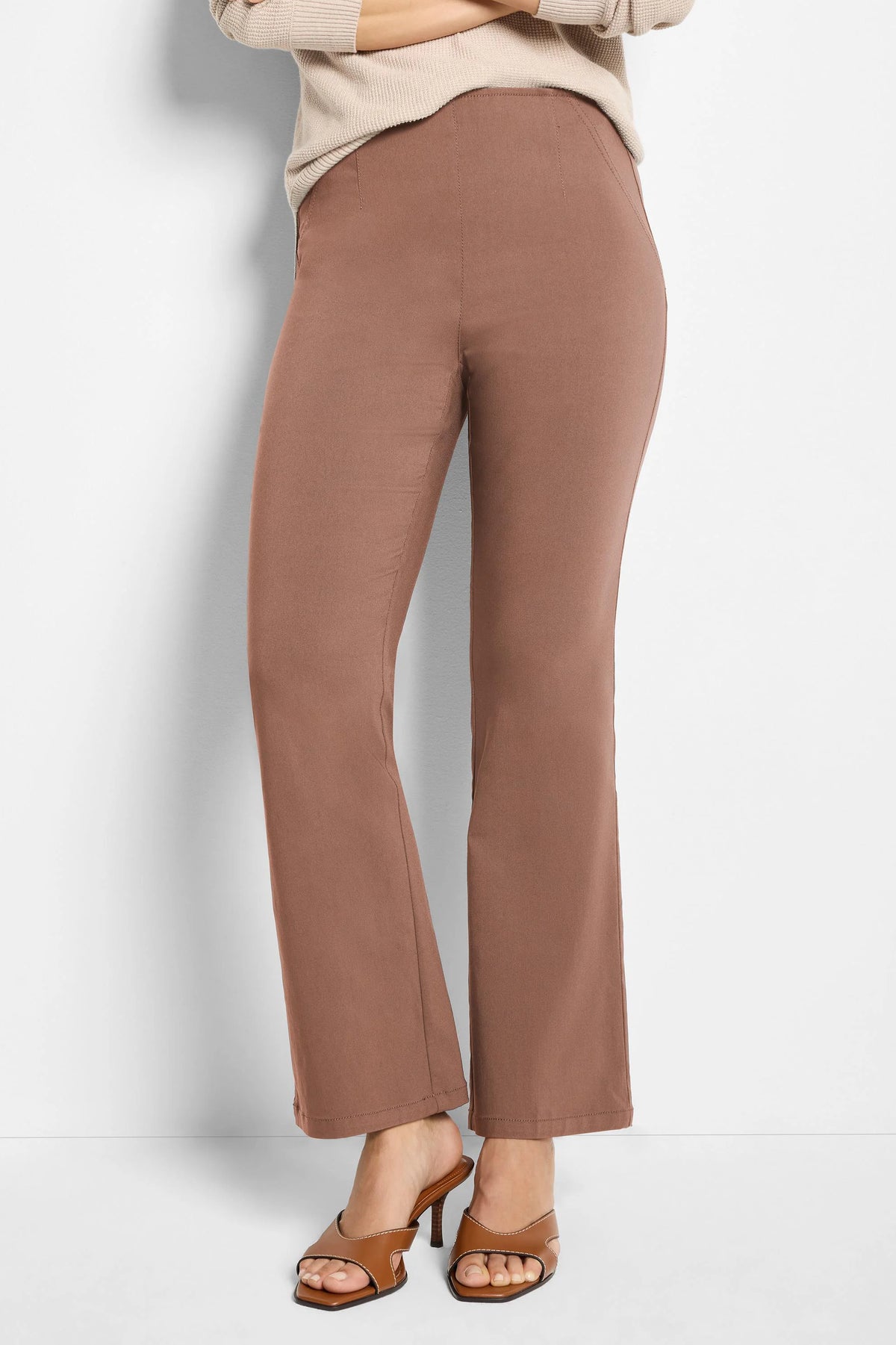 Clay brown boot-cut pants. High-waisted, with a flat front and subtle vertical seams extending from the waist.