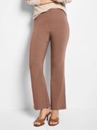 Clay brown boot-cut pants. High-waisted, with a flat front and subtle vertical seams extending from the waist.