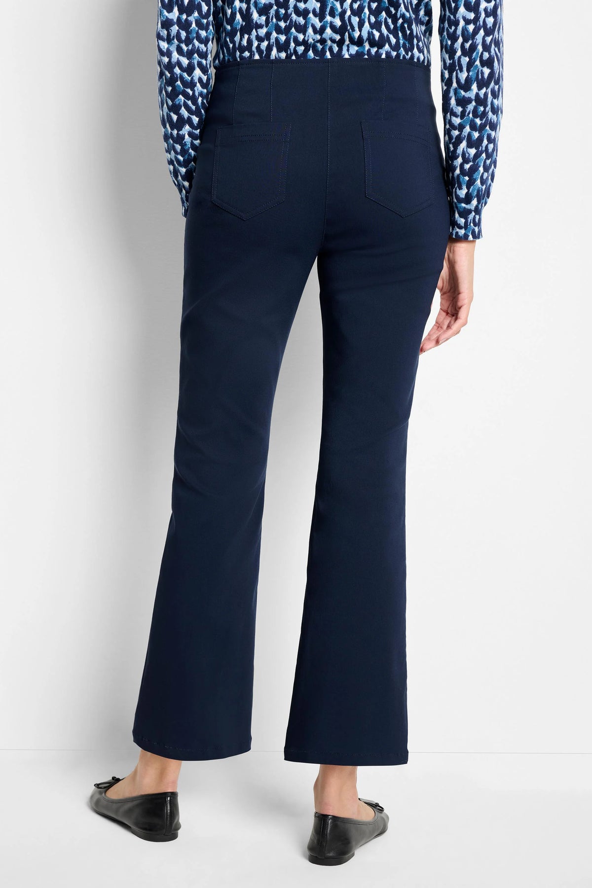 Navy blue bootcut pants, high-waisted with two back patch pockets, shown from rear. Hem ends above ankle.