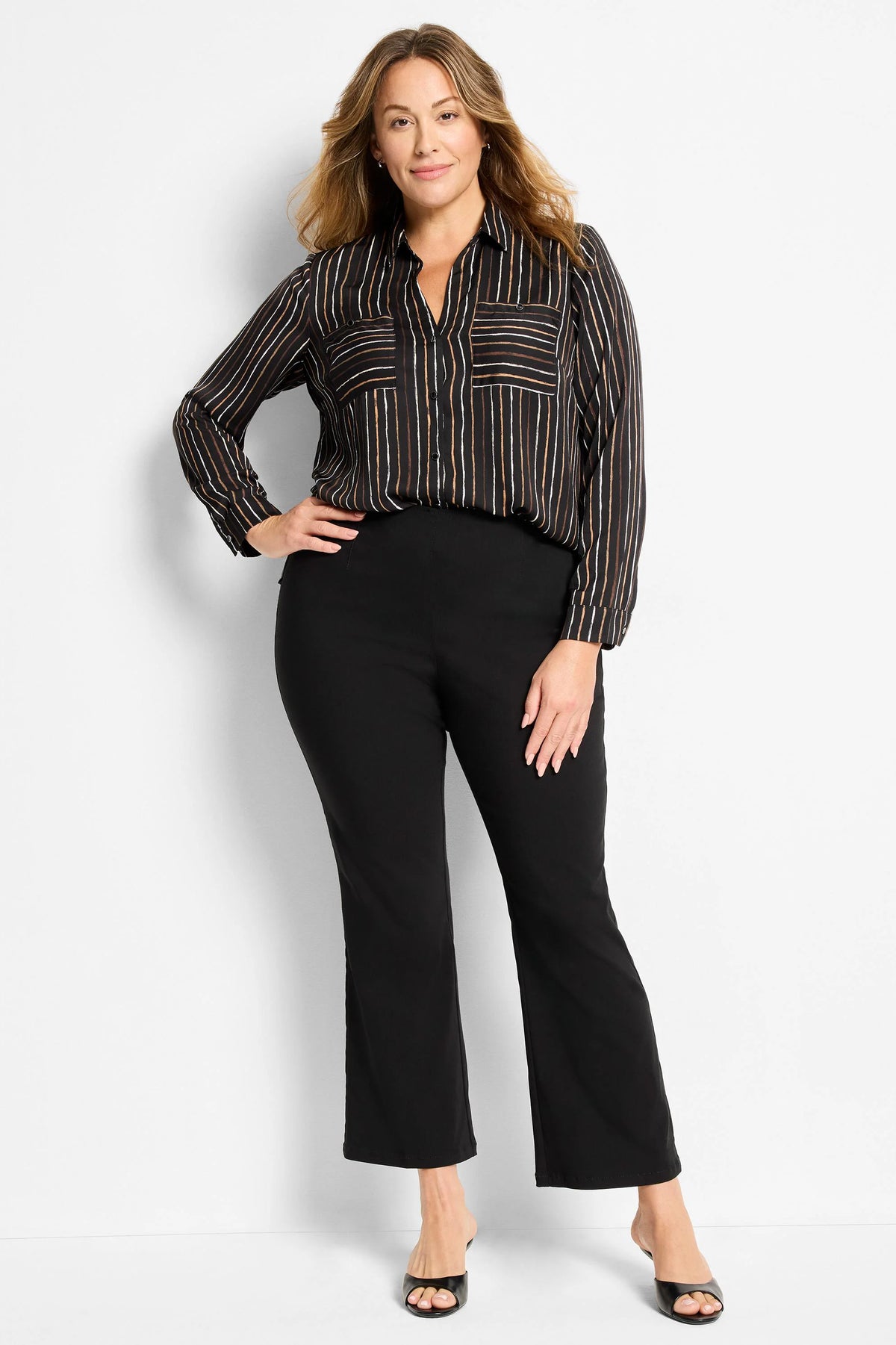Black bootcut pants on a model, cropped length ending above the ankle.