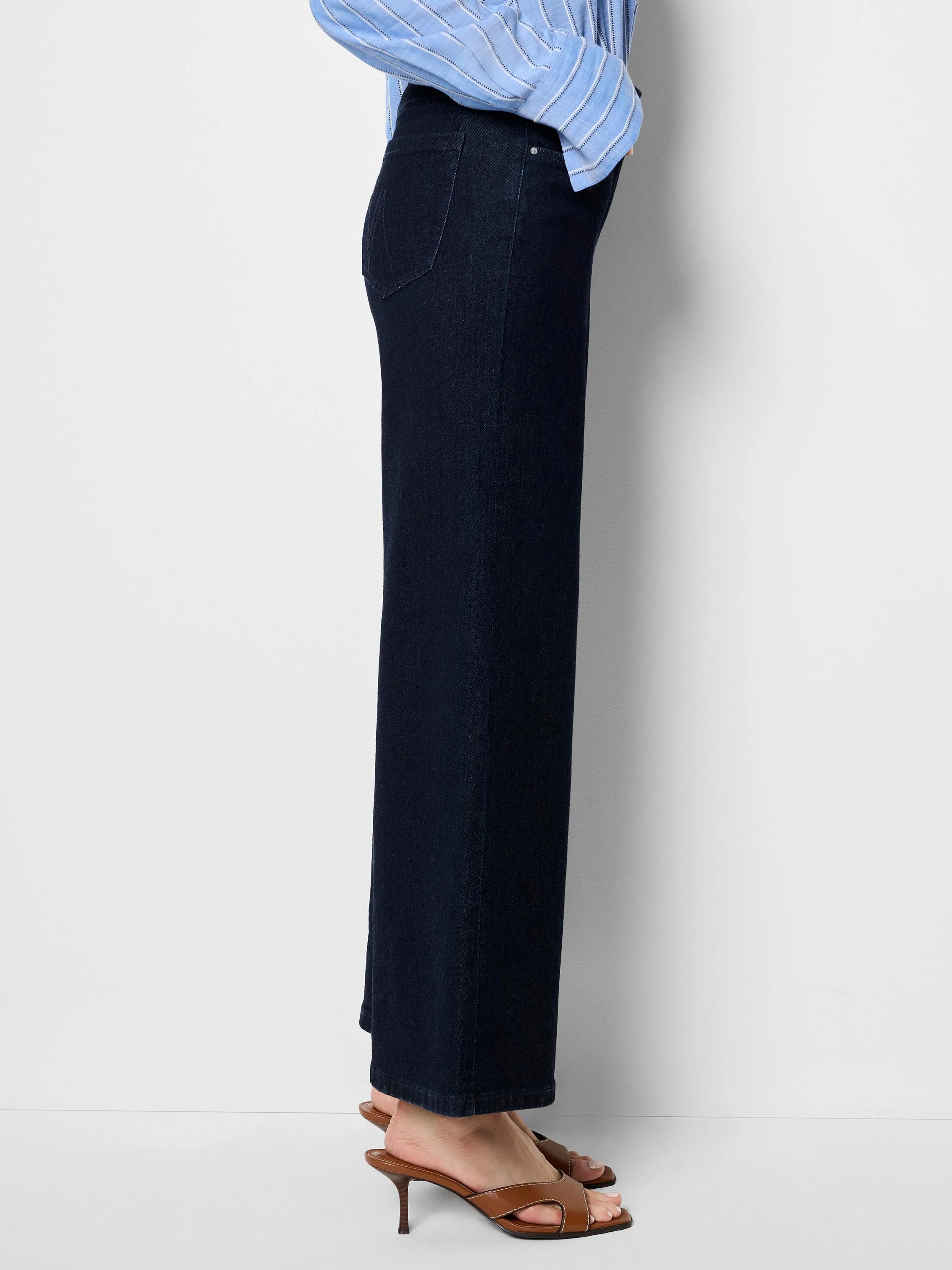Dark indigo boot flare jeans on a model, with a classic back pocket and legs widening from knee to hem.