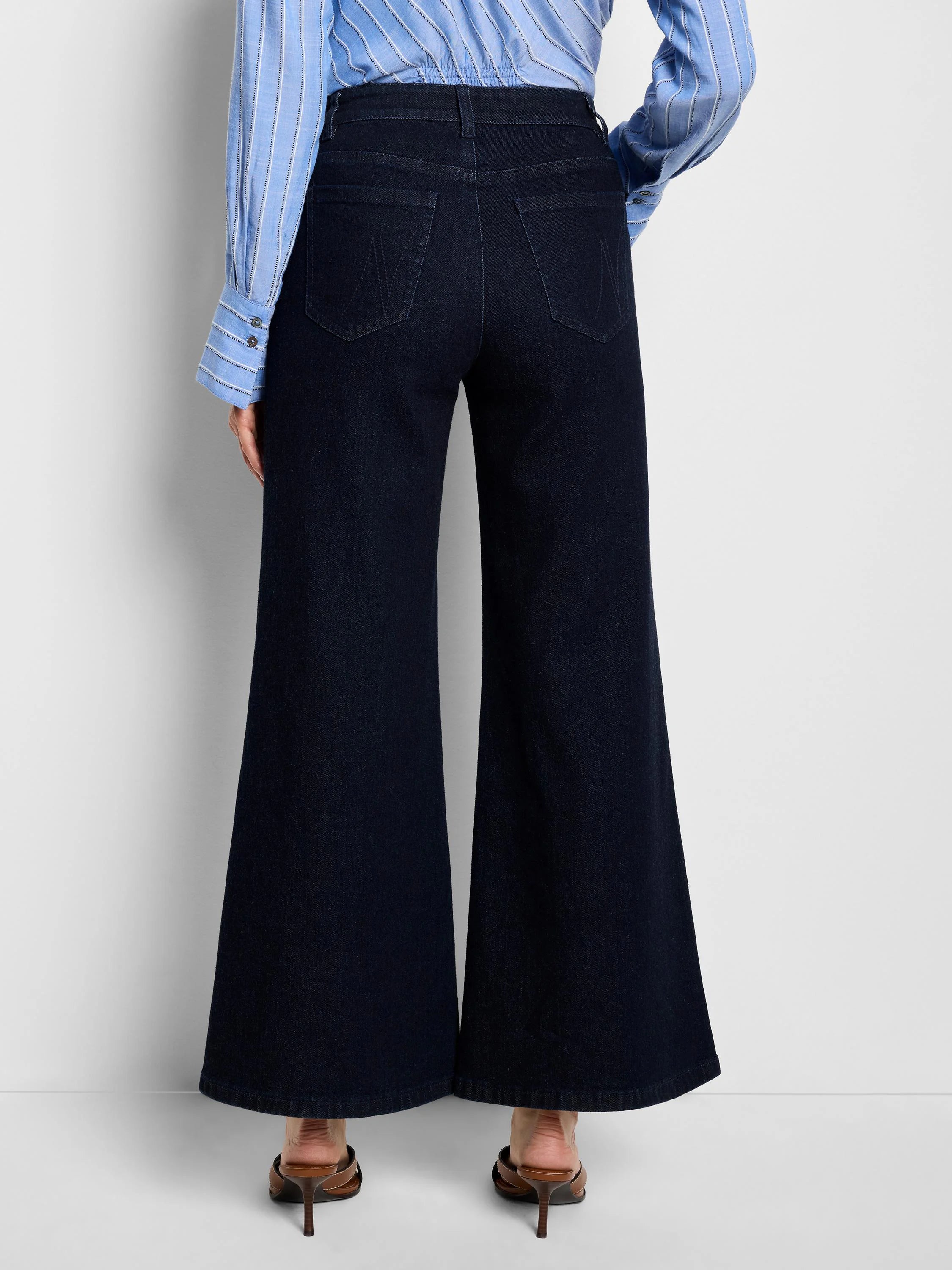 Dark indigo, high-waisted boot-flare jeans, seen from behind. Features subtle back pocket stitching.