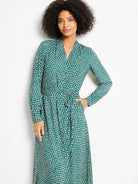 Teal midi wrap dress with cream shadow dots, V-neck, long sleeves, and a tied waist.