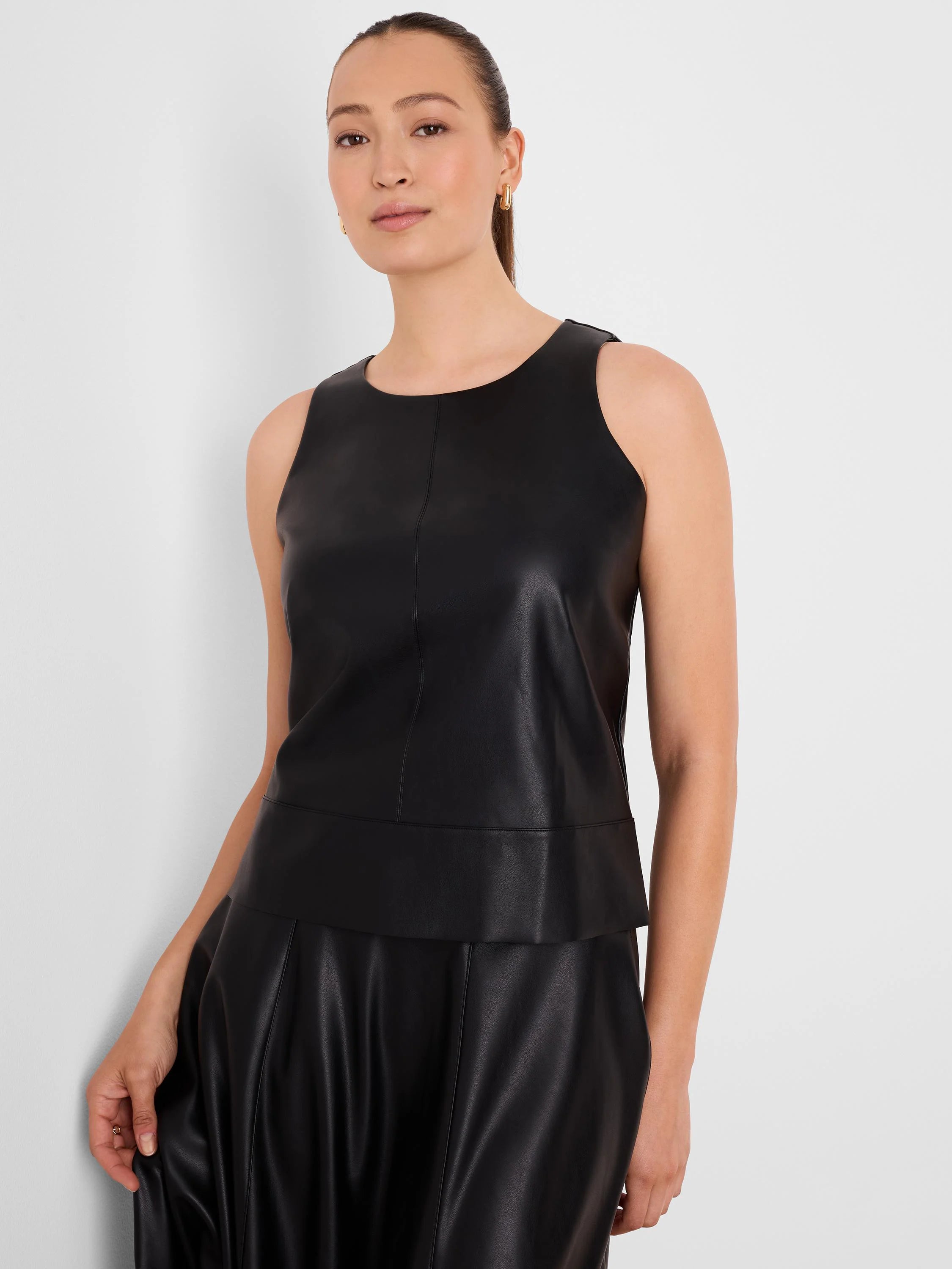 Black vegan leather sleeveless top with a round neck, central vertical seams, and a wide hem band.
