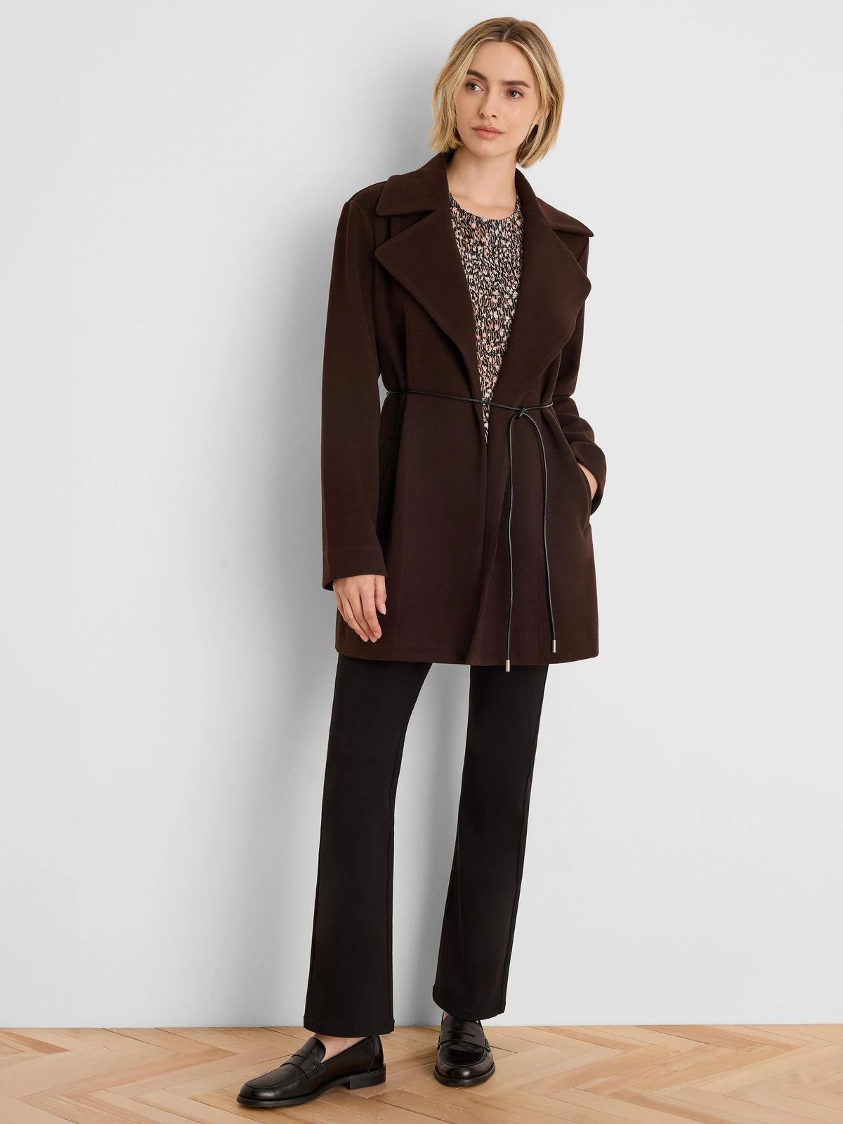 Dark brown knit twill wrap jacket, mid-thigh length, wide lapels, with a thin black tie belt.