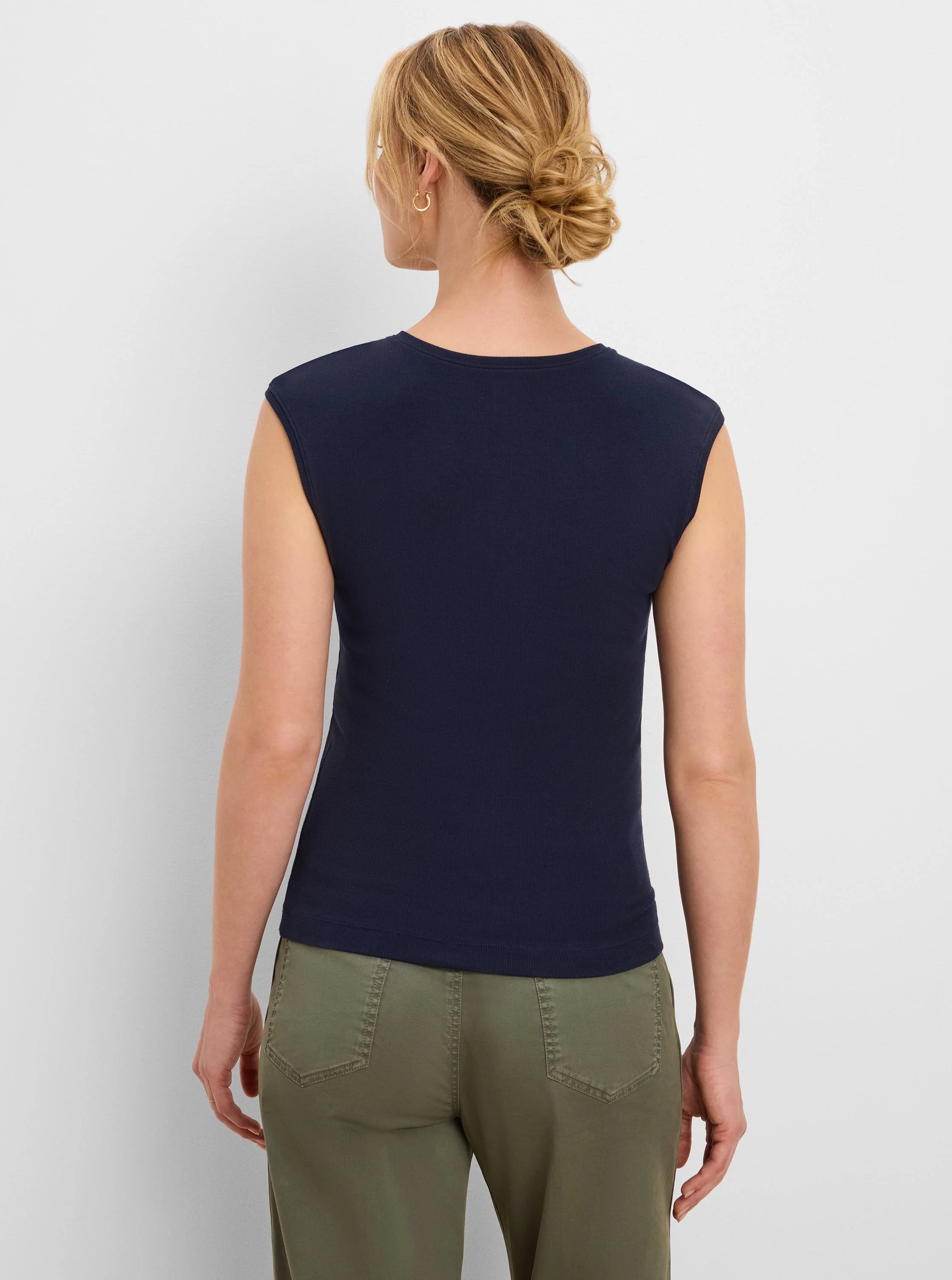 Back view of a woman wearing a navy blue, ribbed, sleeveless tank top with a round neck.