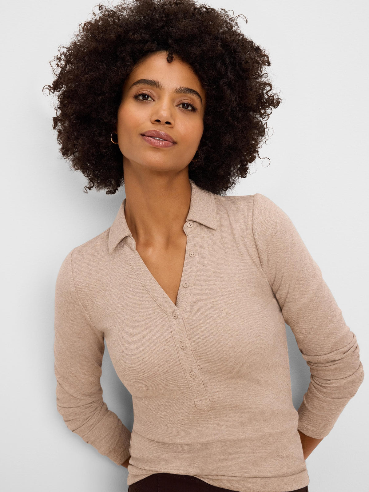 Beige ribbed polo with a collar, button placket, and long sleeves.