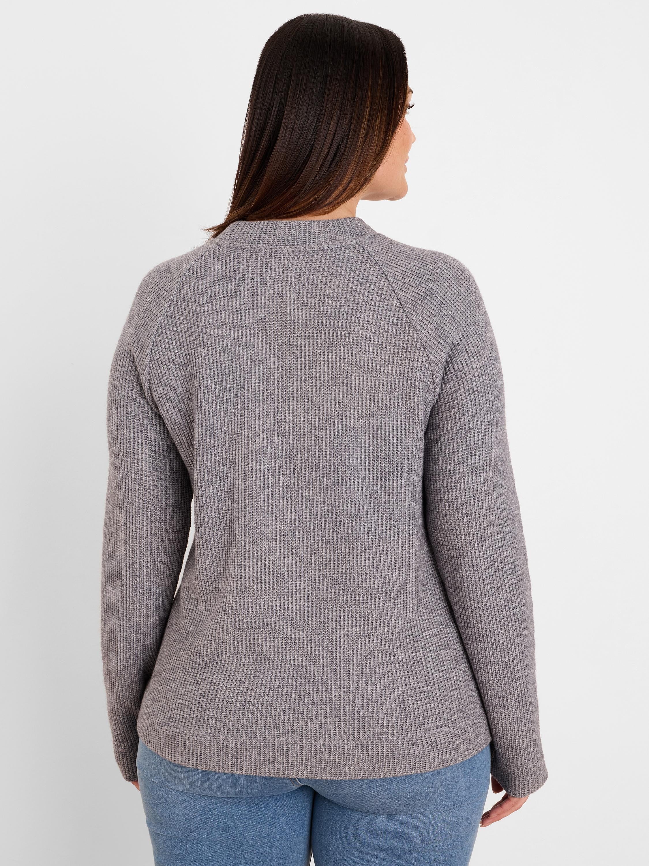 Back of a model wearing a mottled grey waffle knit top. Features long raglan sleeves and a relaxed fit.