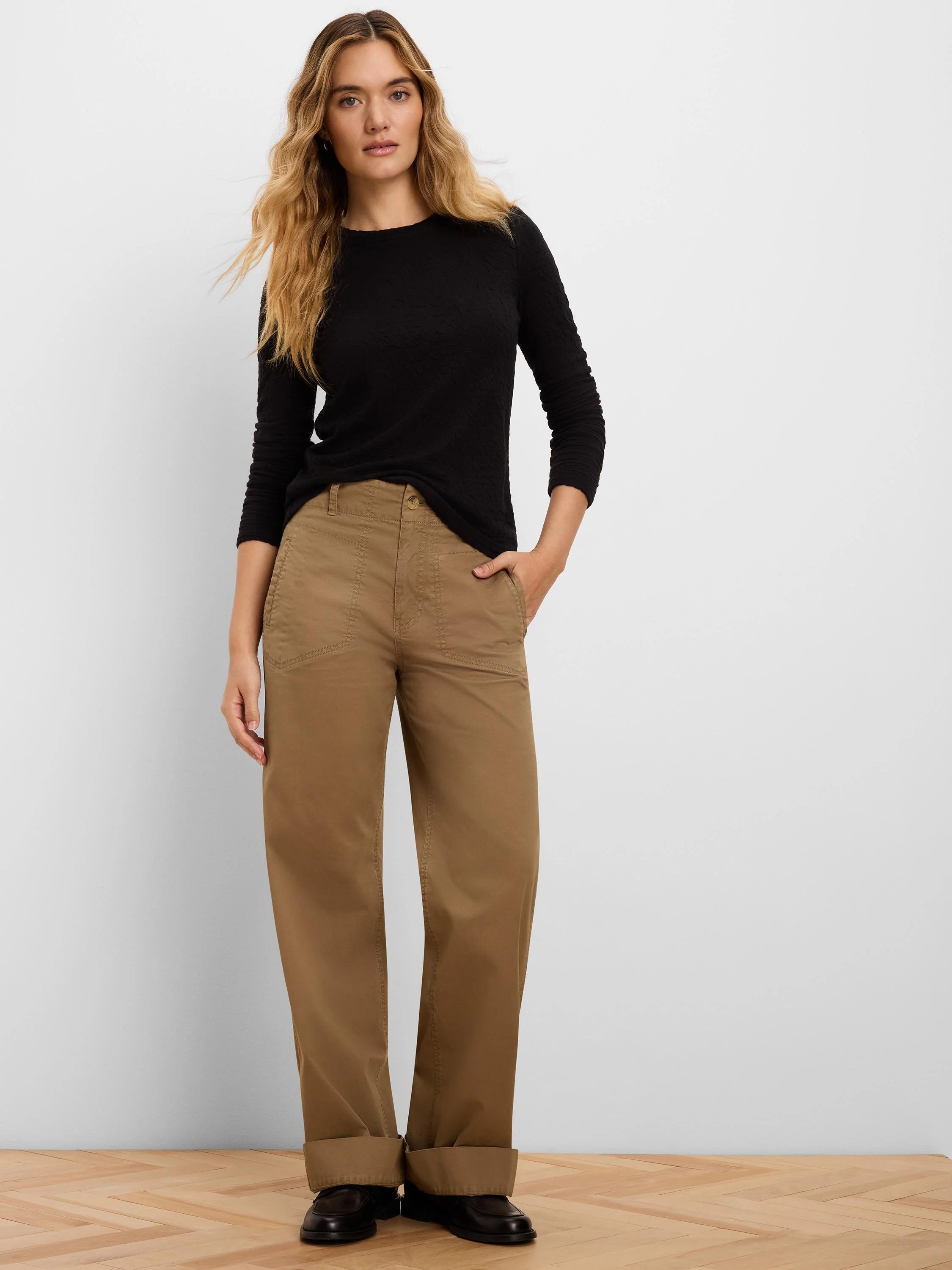 Black long-sleeve top with a round neckline and visible crinkle knit texture.