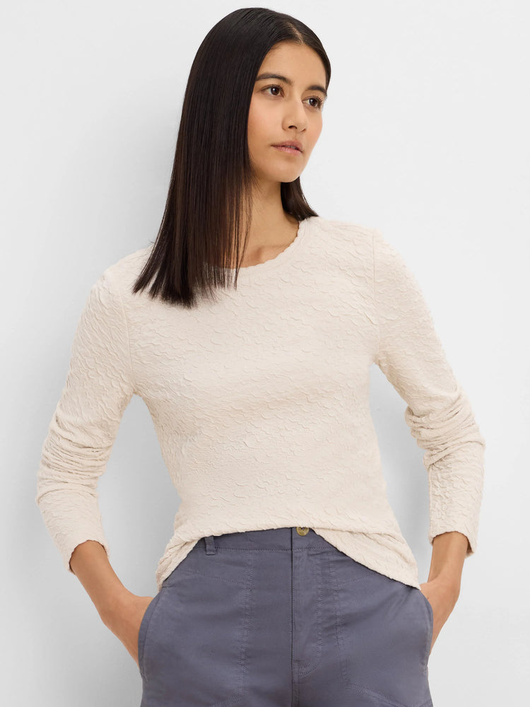 Pale beige, long-sleeved top with a round neck and distinct crinkle knit texture.