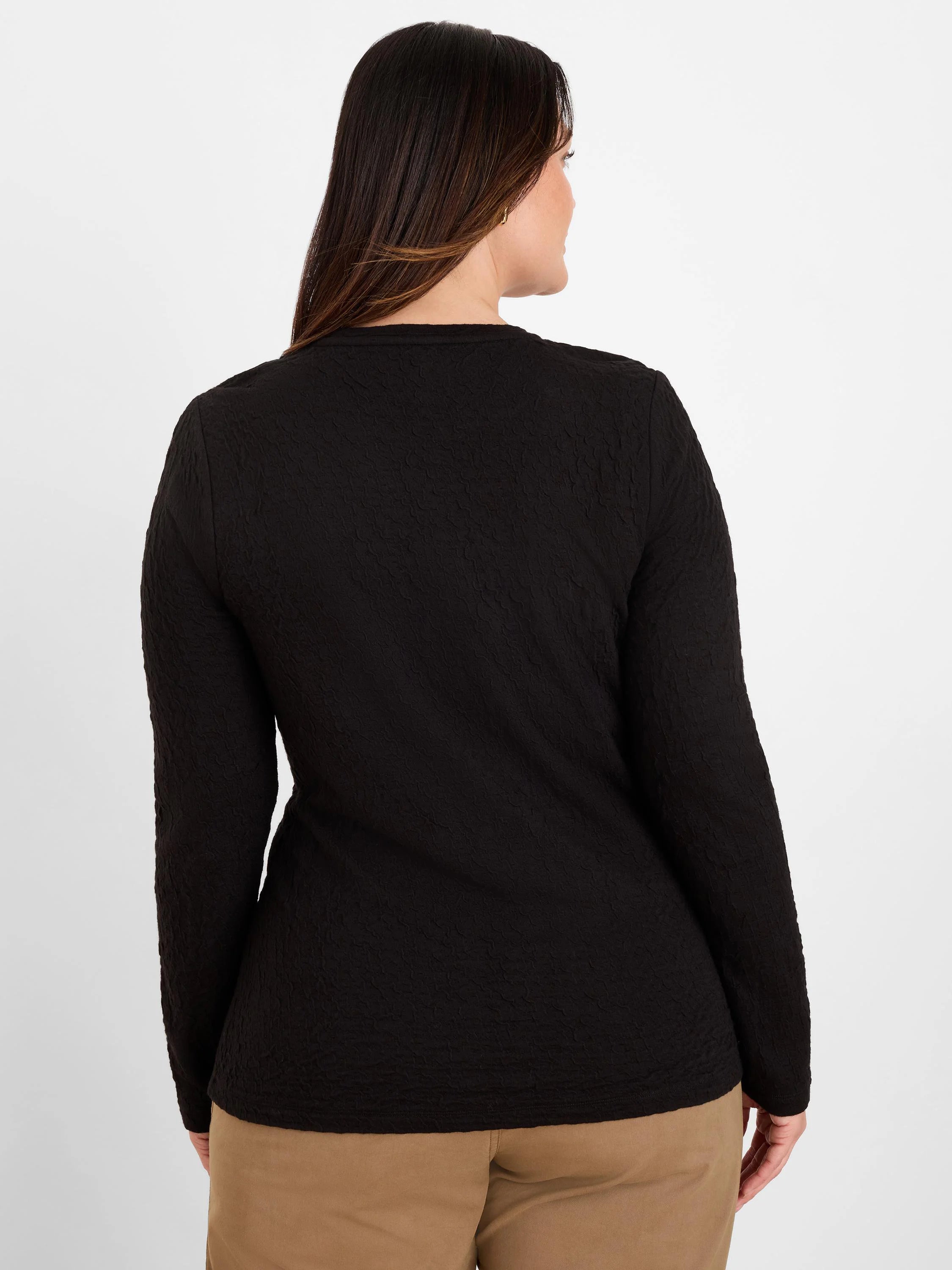 Black crinkle knit long-sleeve top with visible all-over texture, shown from the back on a model.