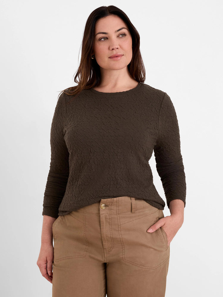 Dark brown crinkle knit top with an all-over puckered texture, 3/4 sleeves, and a round neckline.