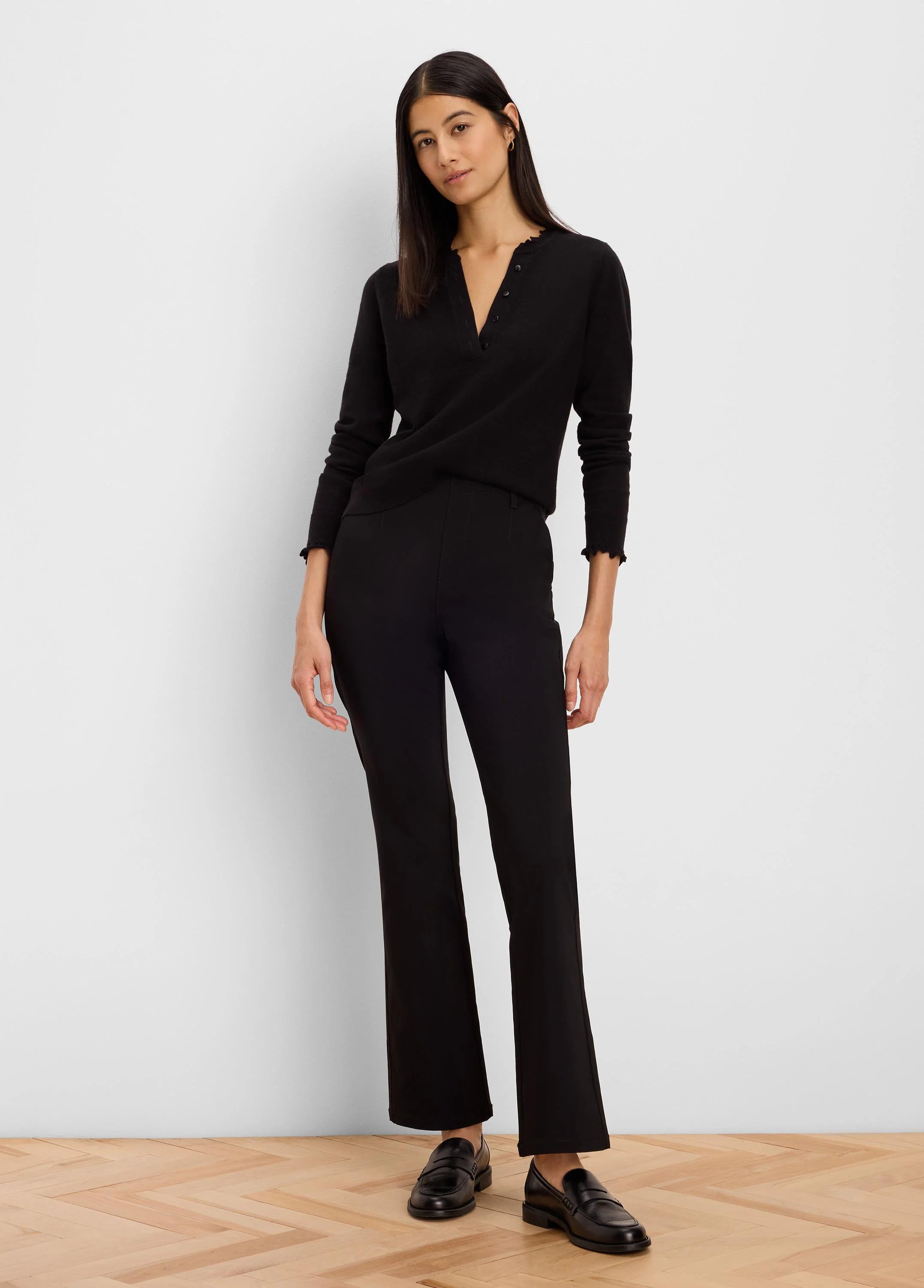Black Henley sweater with ruffled neckline and cuffs.