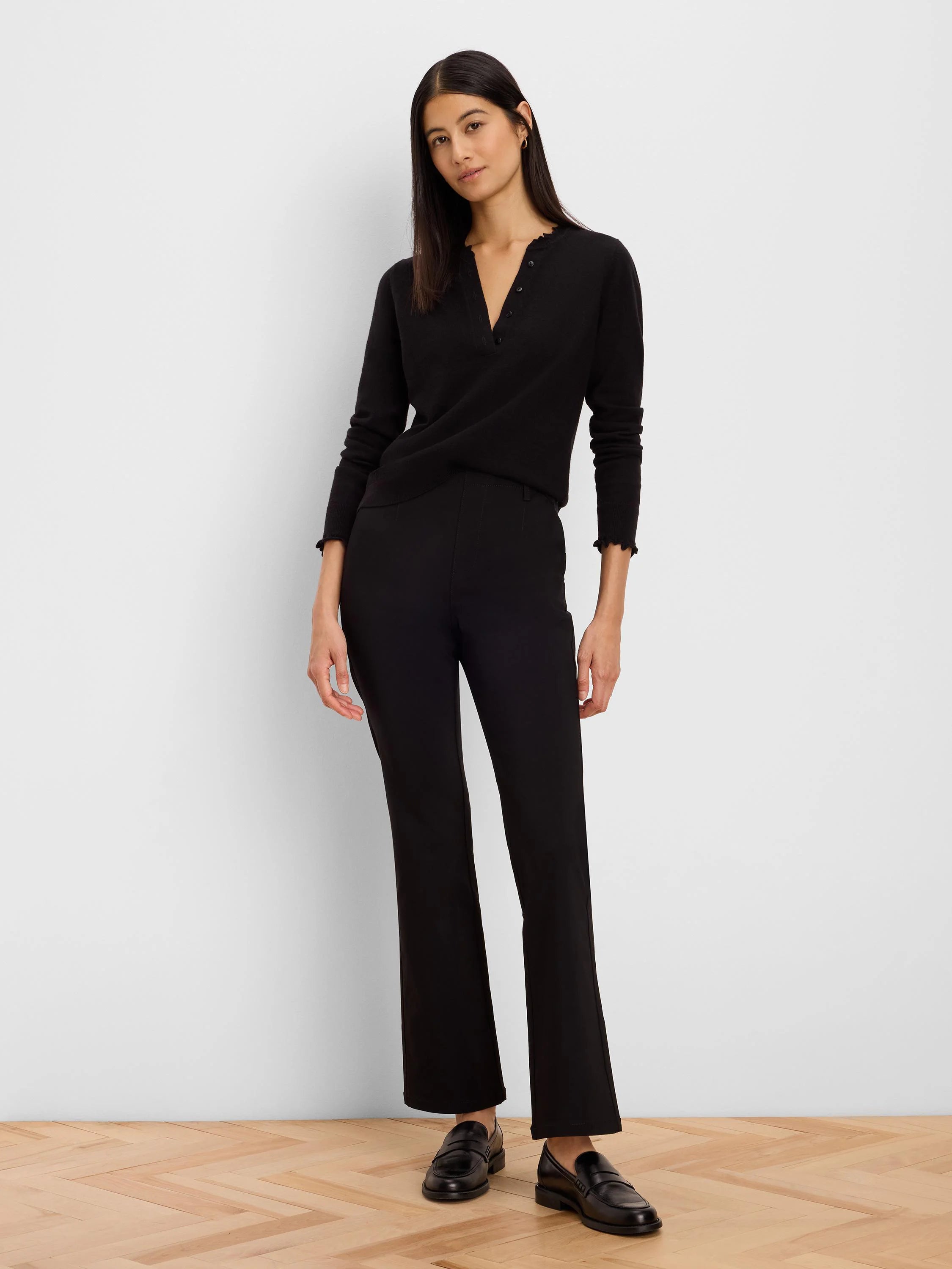 Black Henley sweater with ruffled neckline and cuffs.
