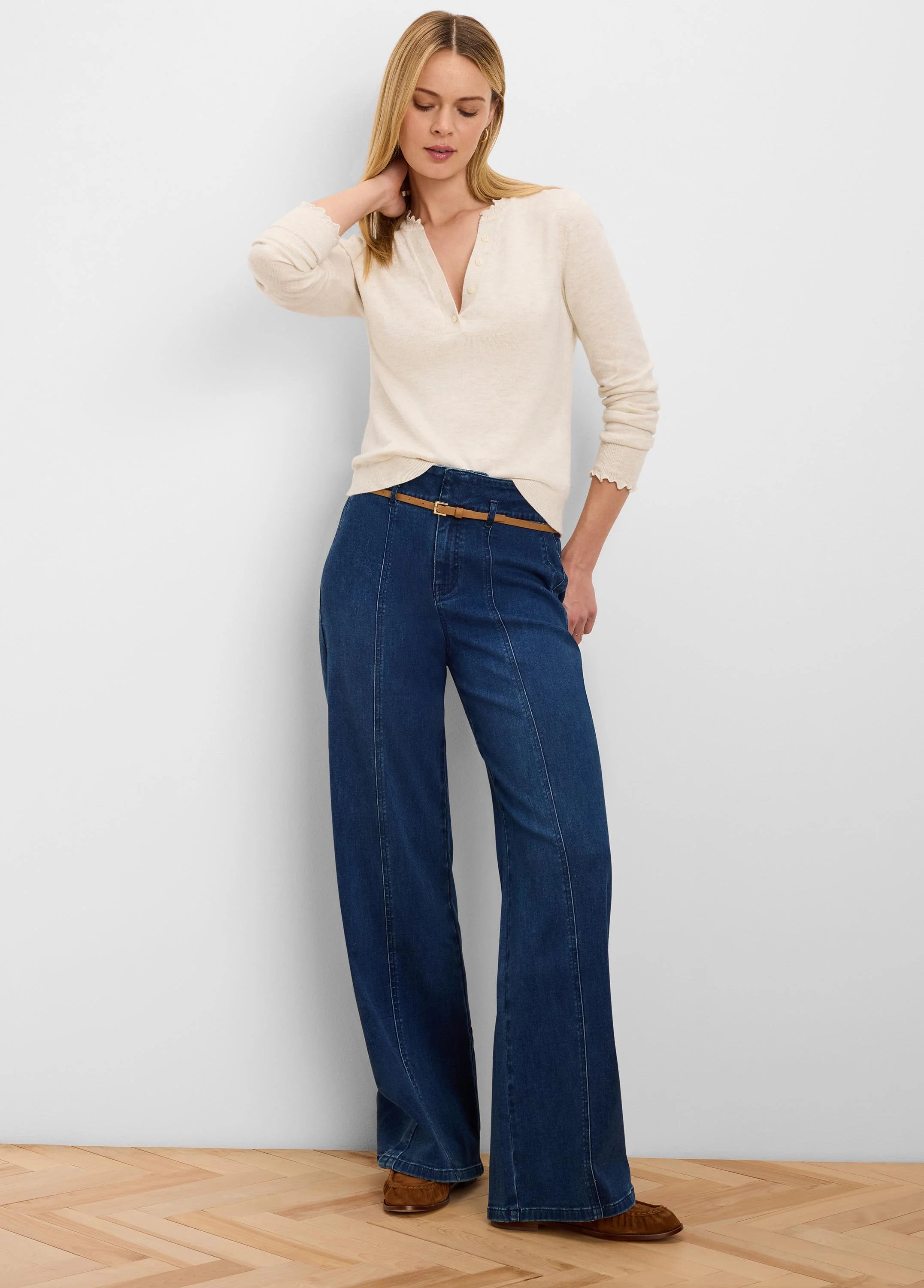 Cream henley sweater with V-neck button placket, ruffled trim on neckline and cuffs.