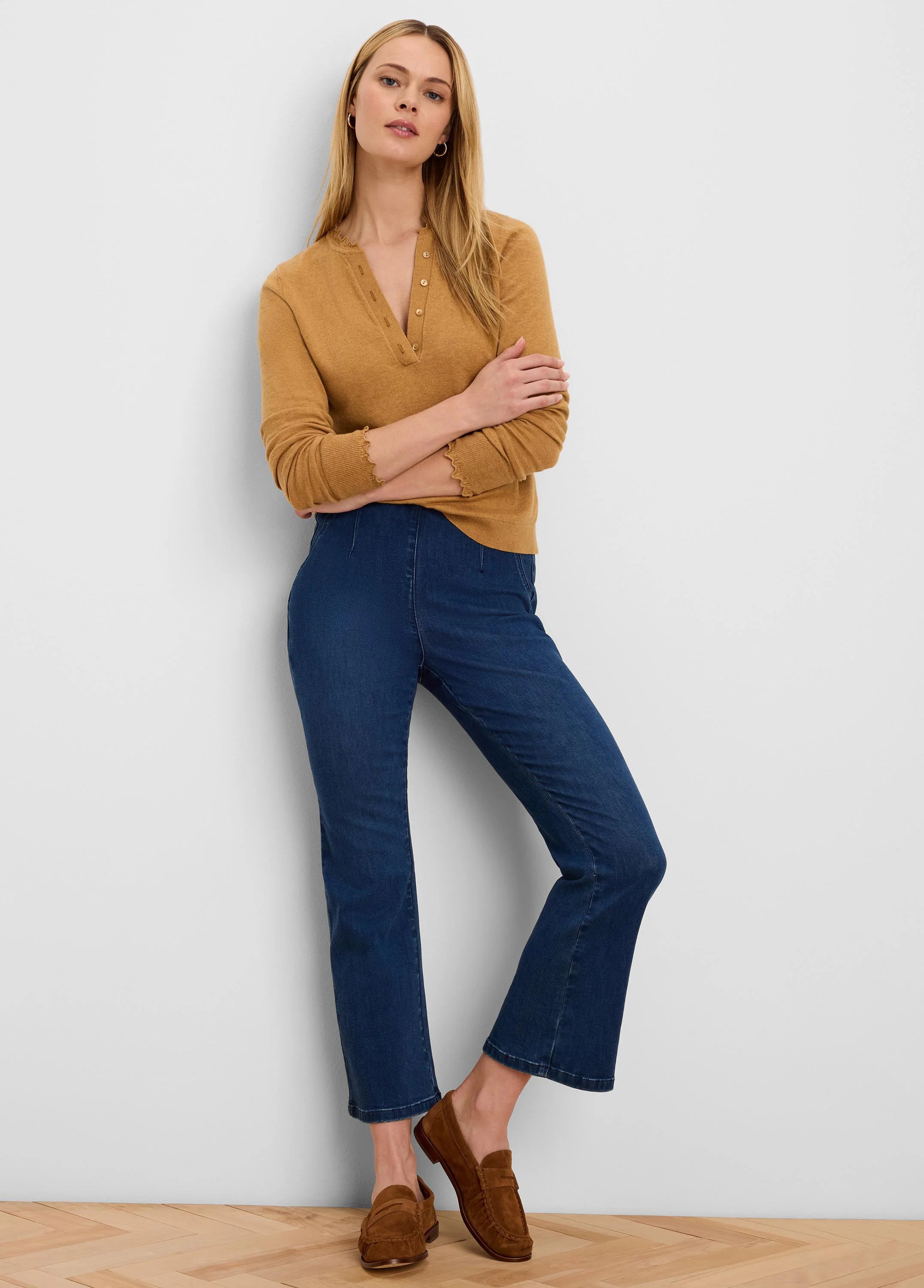 Tan Henley sweater with a button placket, V-neck, and ruffled edges on the sleeves and collar.