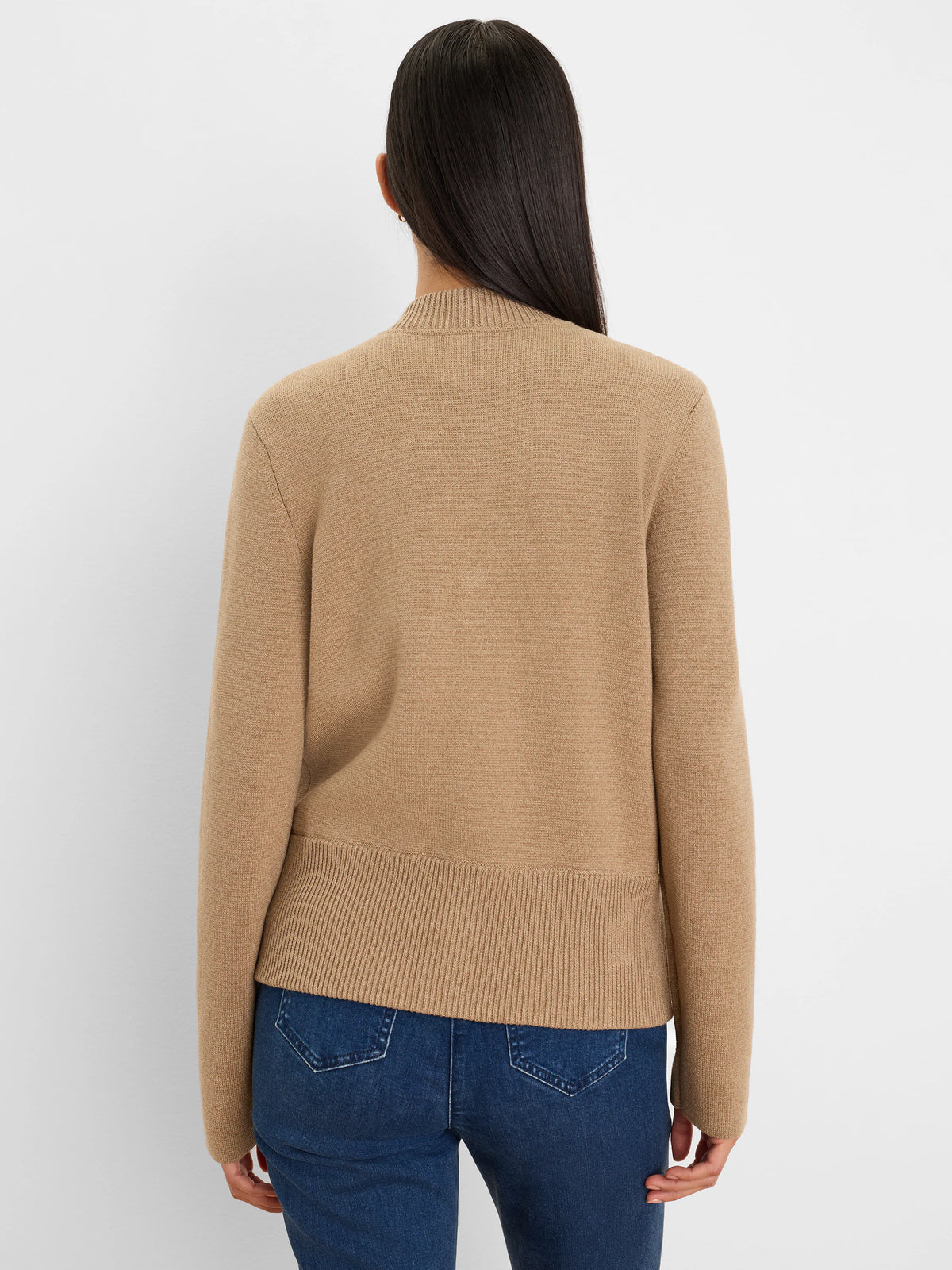 Back view of a tan knit bomber jacket with a ribbed mock neck and hem.