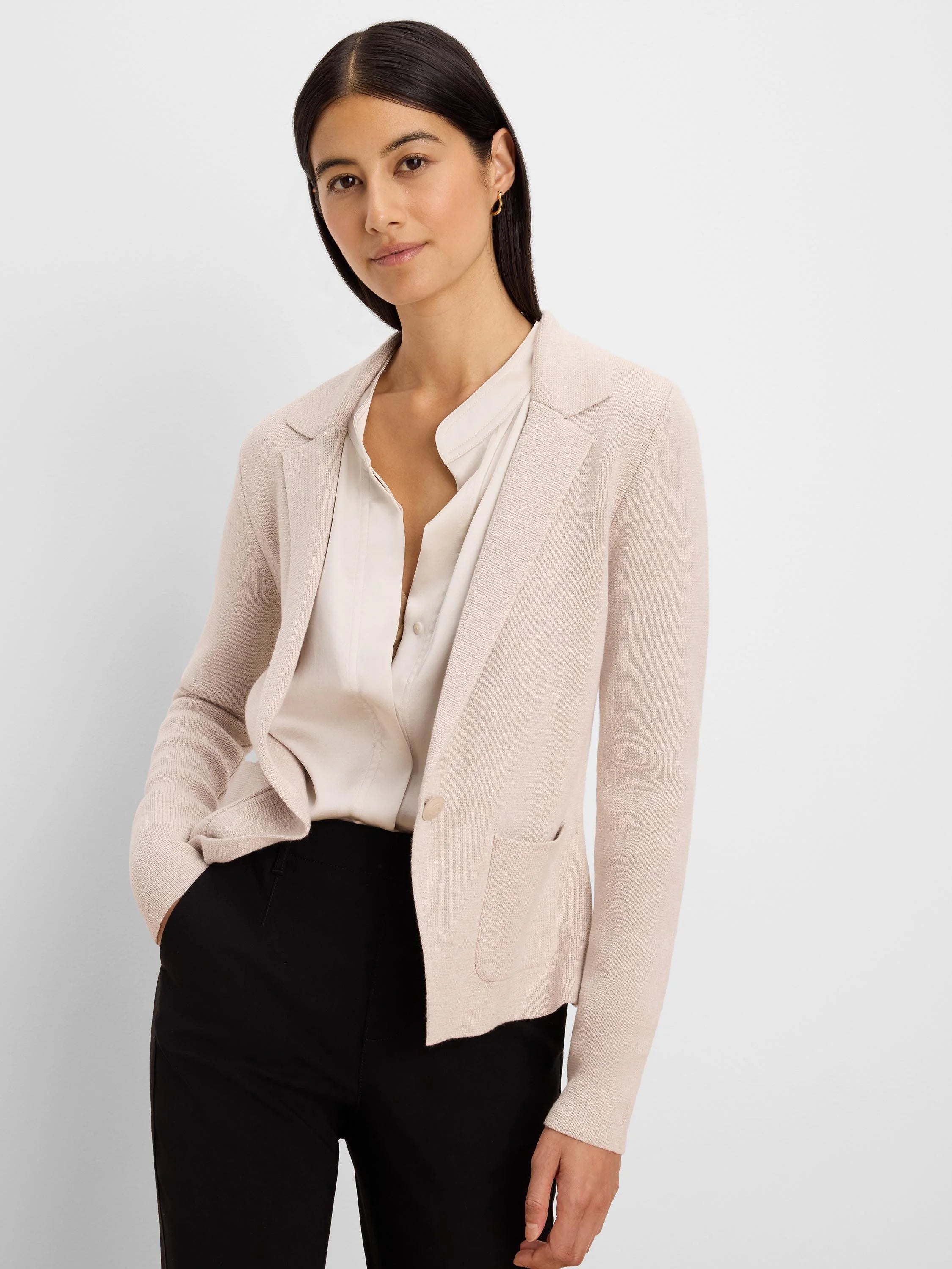 Pale pink knit blazer with notch lapels, one button, and two patch pockets.
