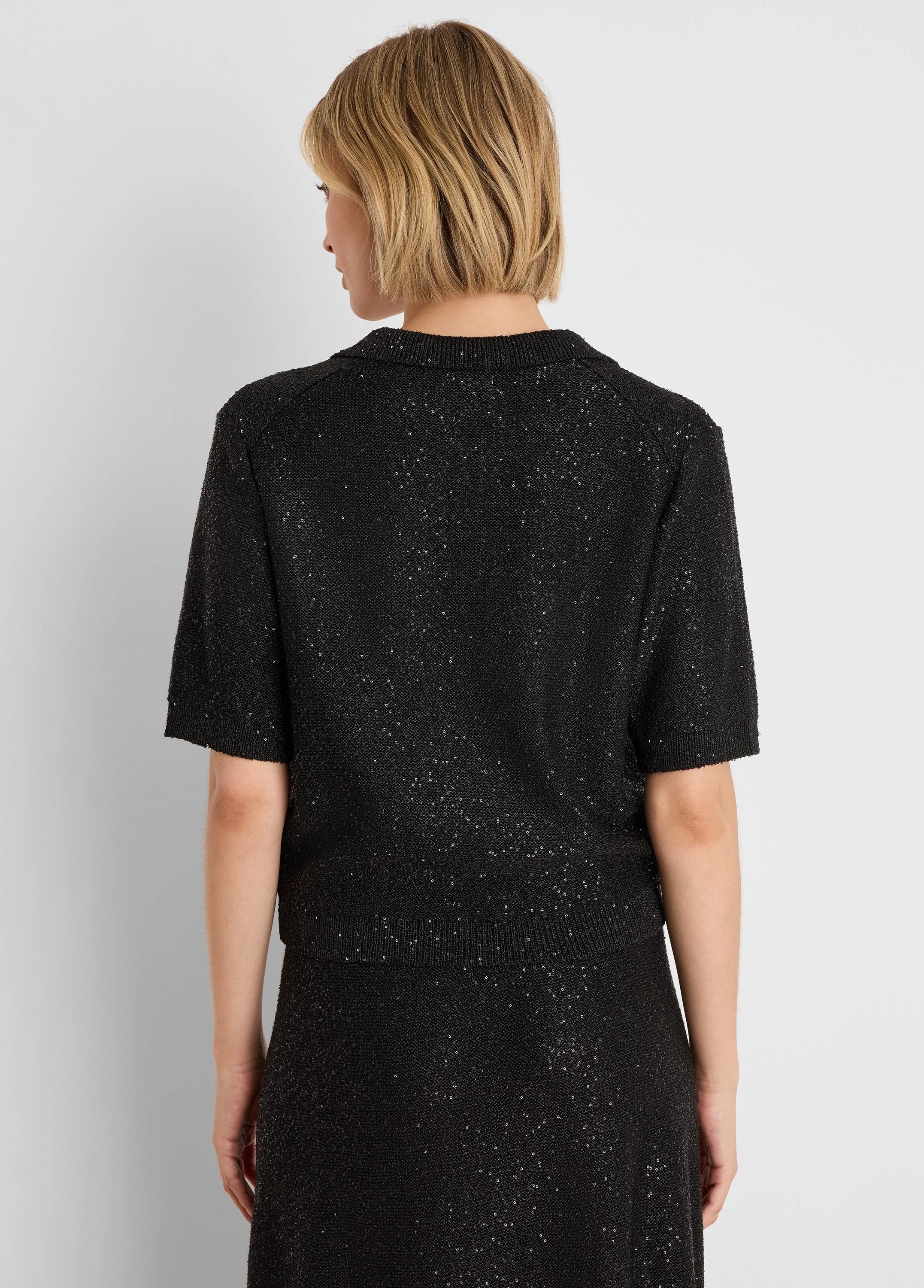 Black sequin polo sweater with short sleeves and ribbed collar, shown from the back.