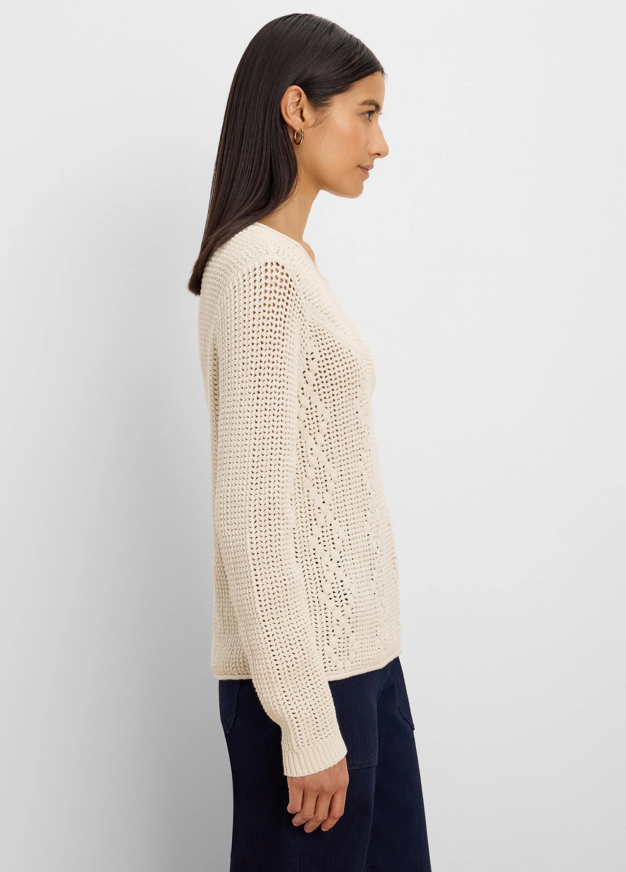 Cream loose-knit sweater with mixed diamond stitch patterns.