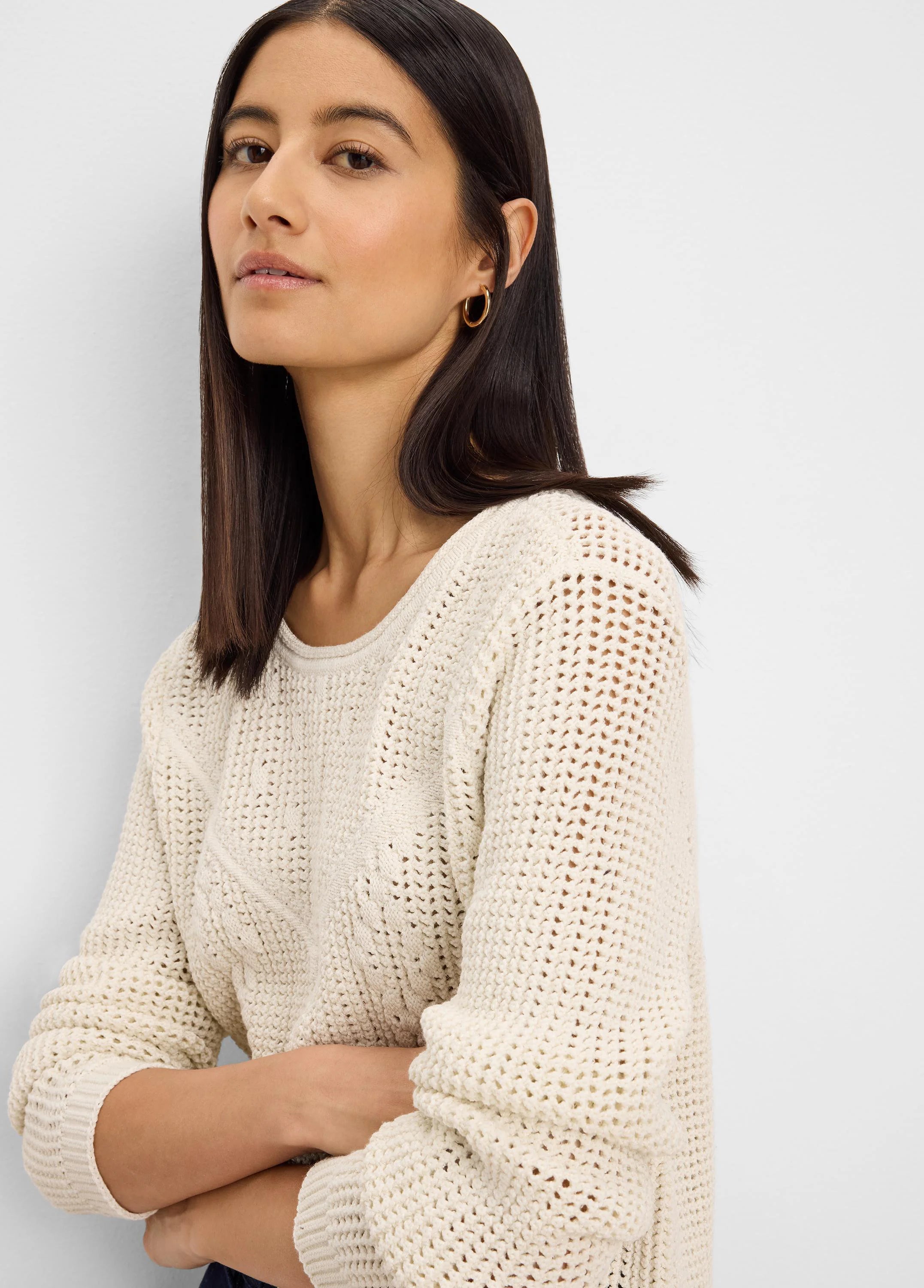 Cream sweater featuring a mix of open-knit, diamond, and ribbed stitch patterns.
