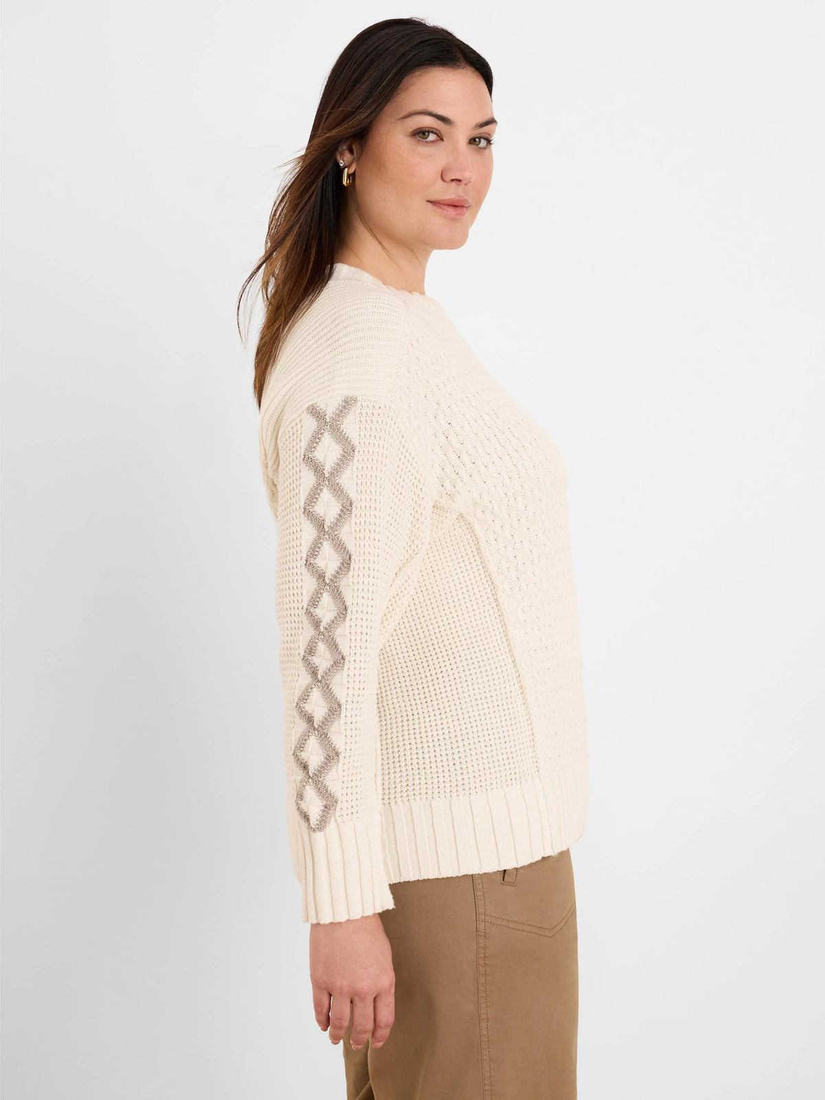 Cream sweater with taupe diamond criss-cross patterns on the sleeves. Features a textured knit body, ribbed cuffs and hem.