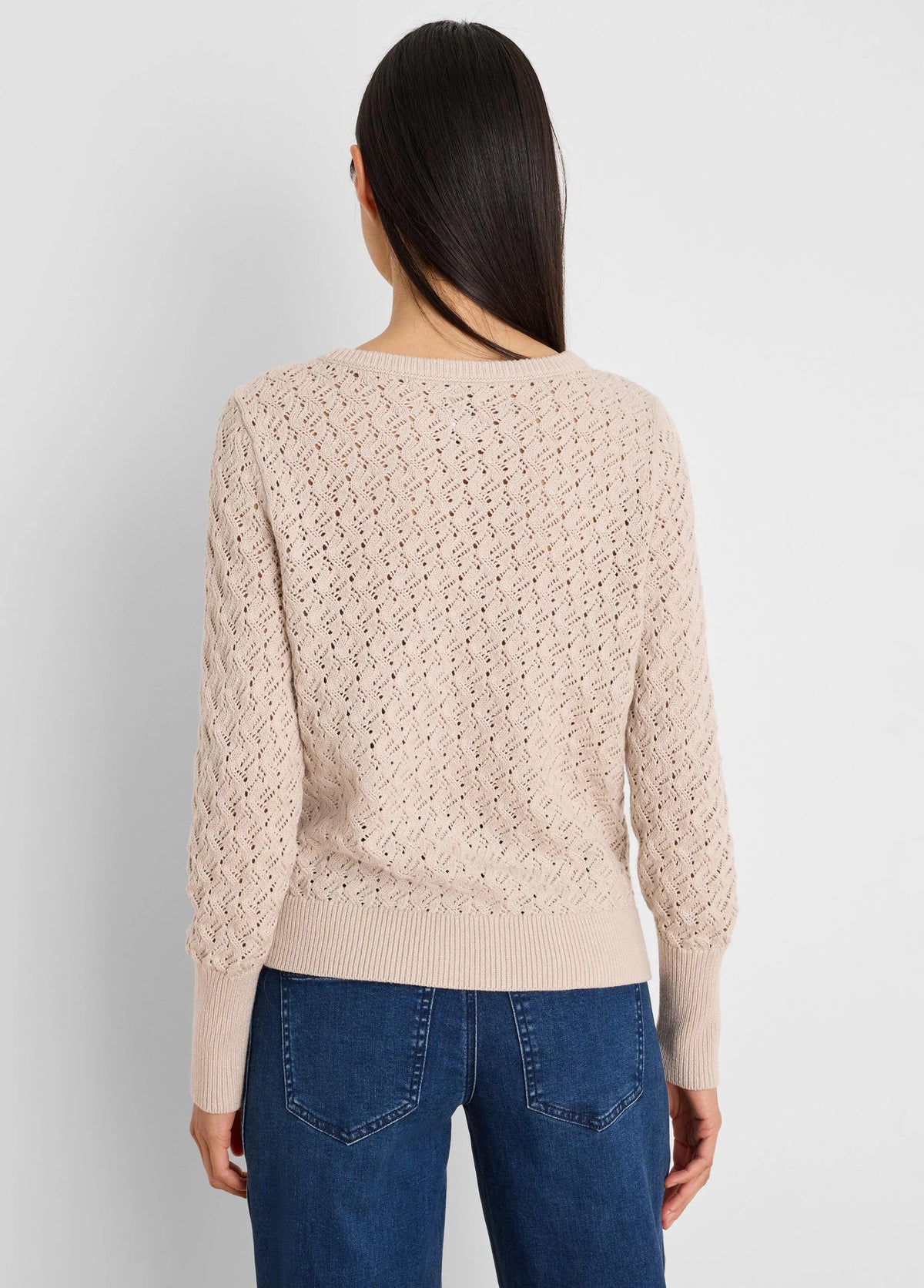 Beige open-knit sweater with a repeating diamond pattern, ribbed cuffs and hem. Model shown from back.