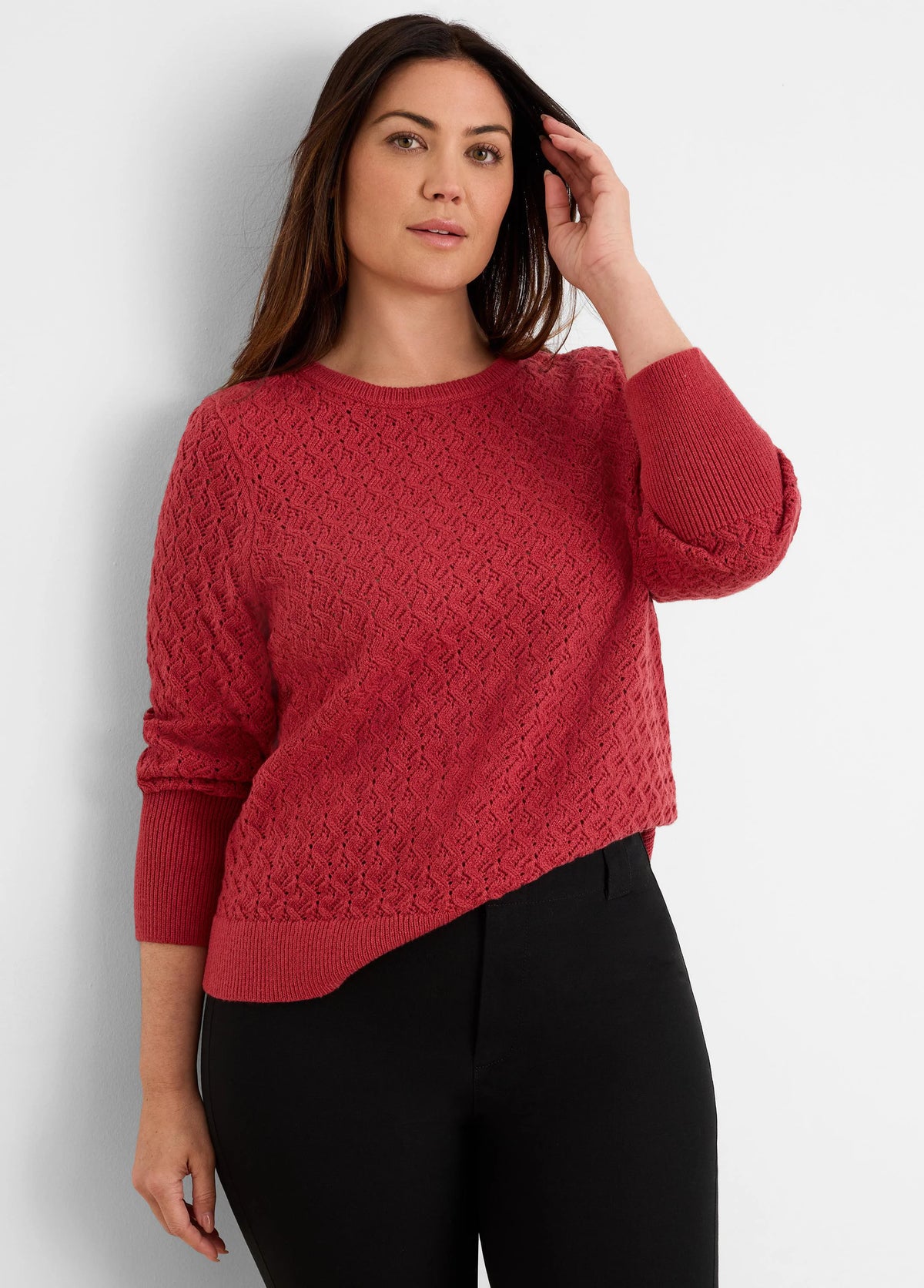 Dark red crew neck sweater with an open-knit diamond stitch, ribbed cuffs, and an asymmetrical hem.