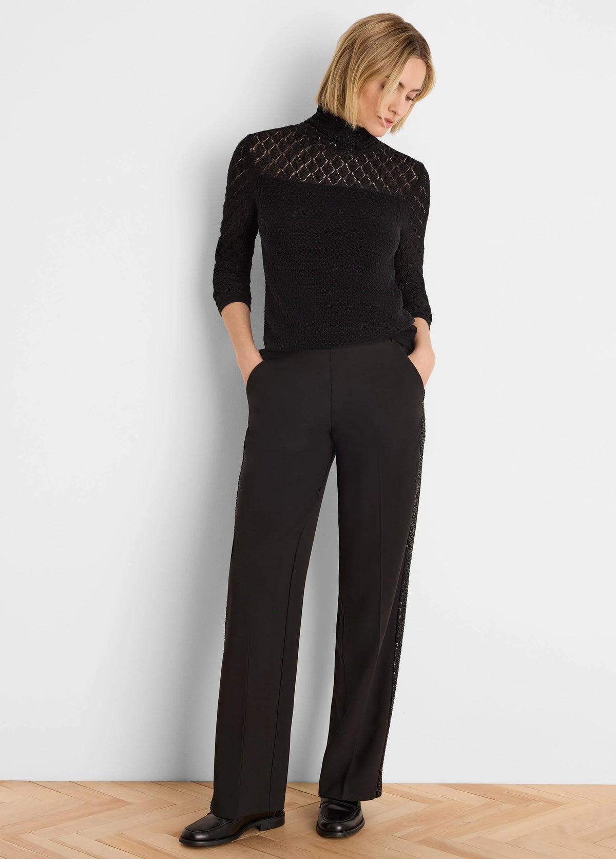 Black knit turtleneck sweater. Diamond lace pattern on shoulders/upper sleeves, solid knit torso. 3/4 length sleeves.