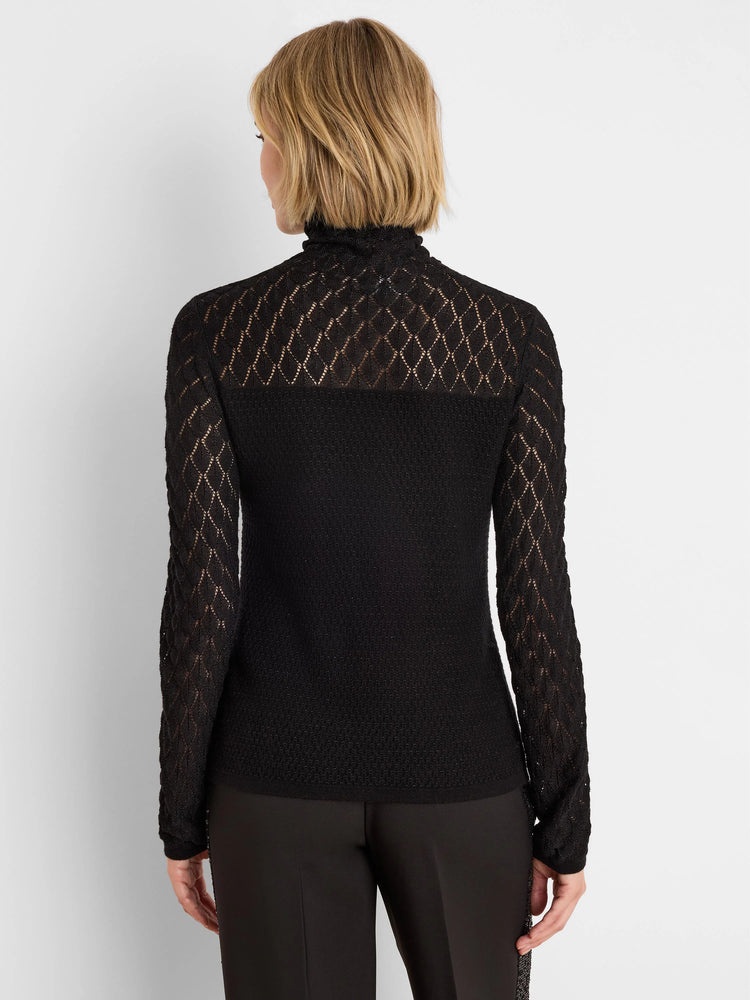 Black knit lace turtleneck sweater. Sheer diamond lace pattern on sleeves and upper back; opaque knit torso.
