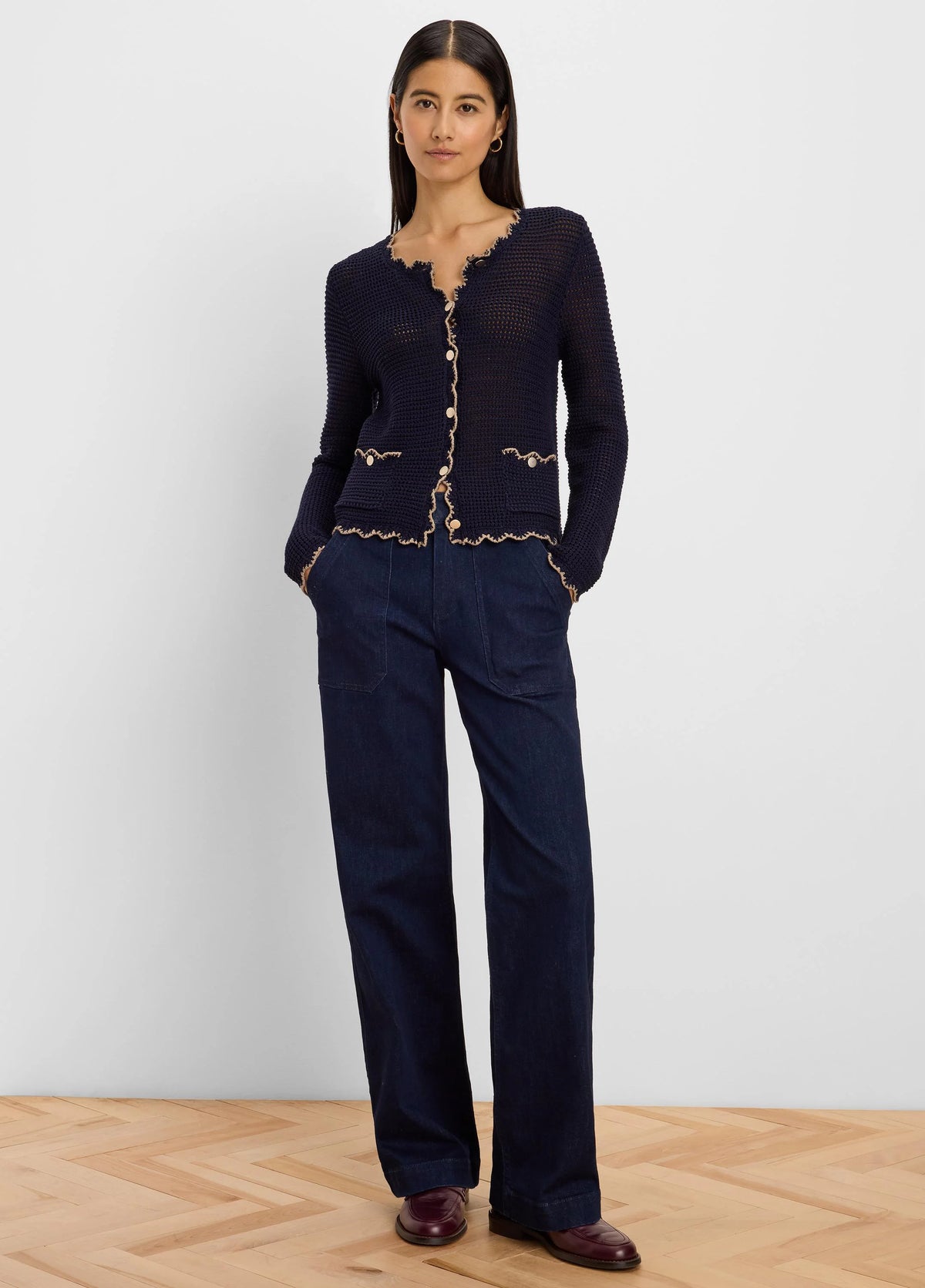 Navy mesh cardigan with scalloped beige trim, light buttons, and two front pockets.