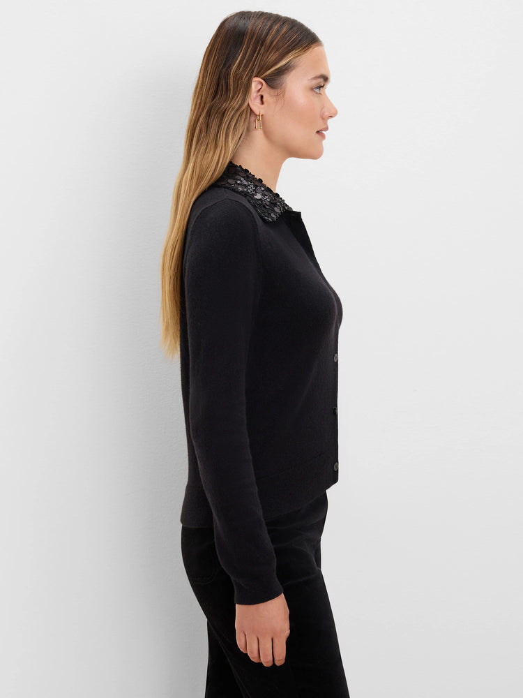 Black cardigan with a textured black sequin collar and black buttons.