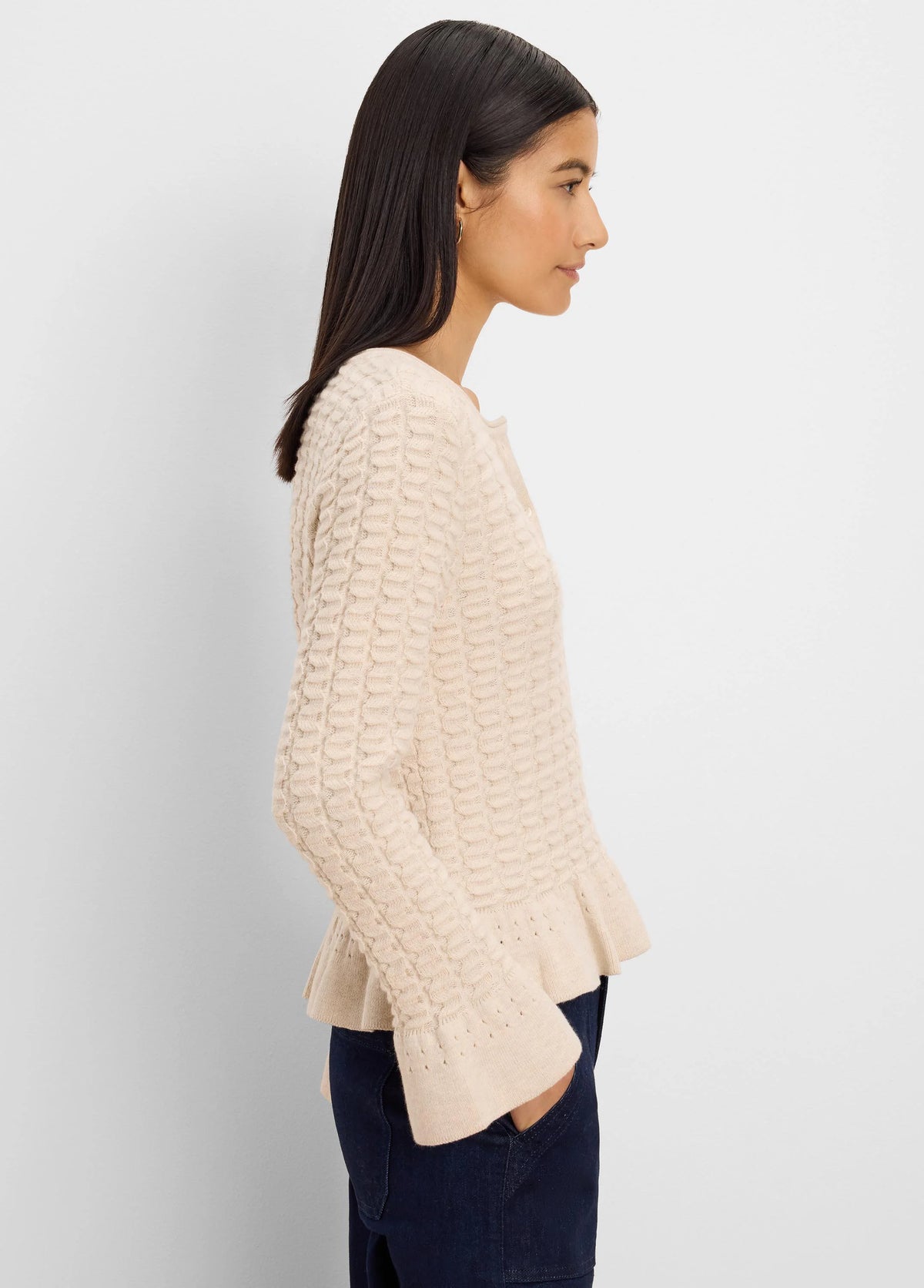 Pale beige cardigan with raised knit texture, frilled hem & cuffs, and front buttons.