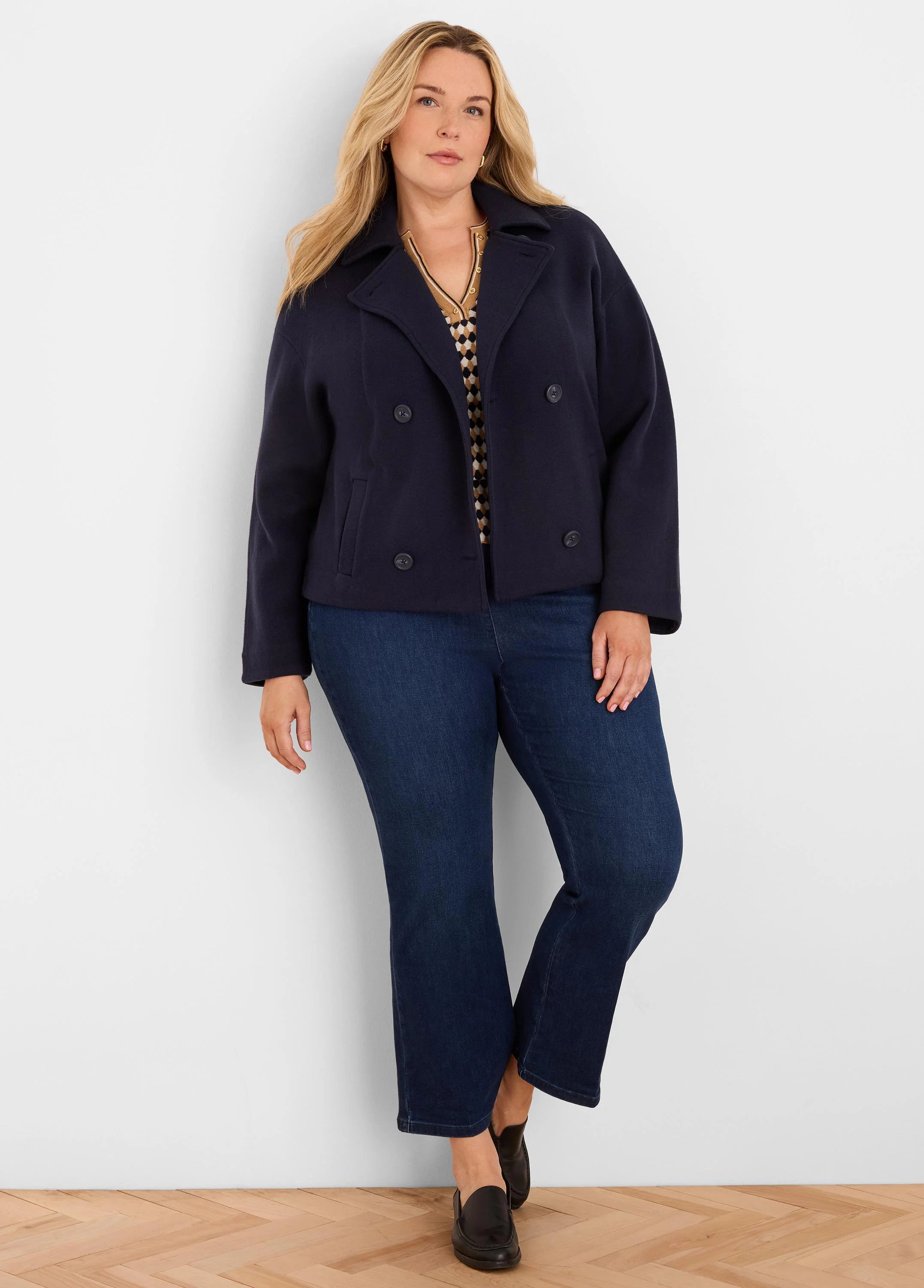 Angled tan & black diamond jacquard sweater with V-neck and gold buttons.