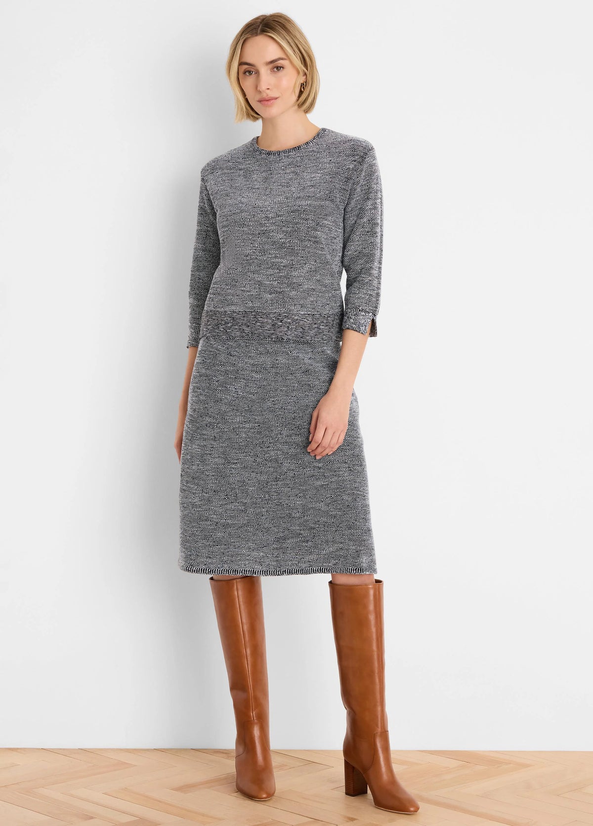 Knee-length marled dark grey and white tweed stitch knit sweater. Round neck, 3/4 sleeves, ribbed waist & slit cuffs.