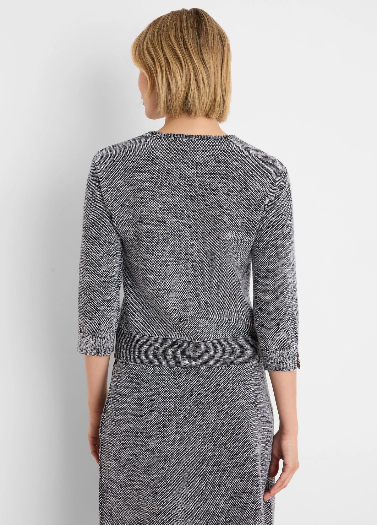 Tweed stitch sweater in speckled black, white, and blue with a round neck and 3/4 sleeves.