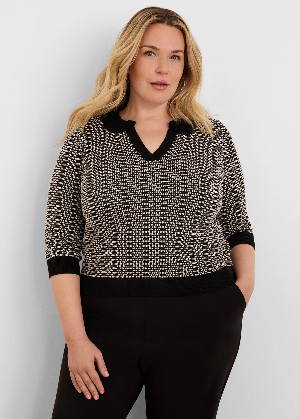 Black & beige geo stitch sweater with 3/4 sleeves, ribbed black cuffs & hem, and a black lace-trim V-neck.