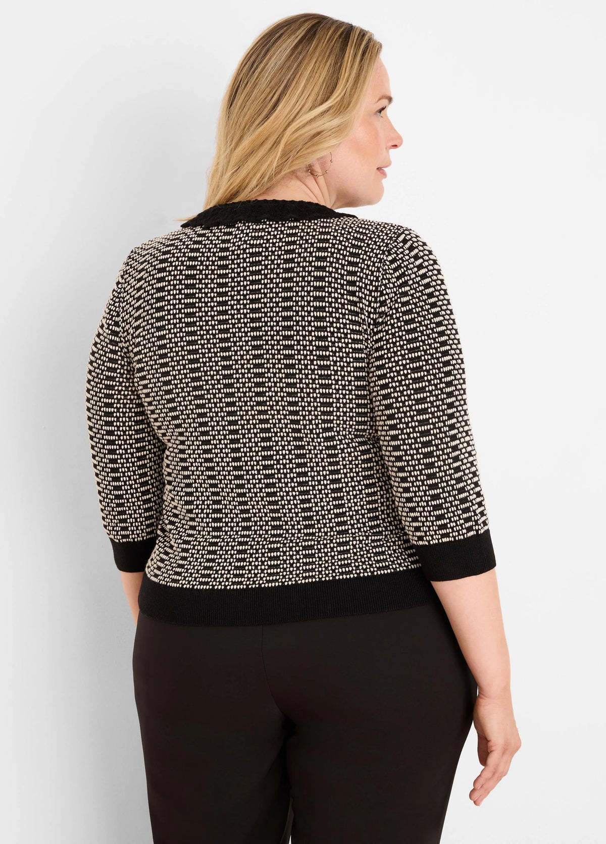 Black and cream geo stitch sweater with 3/4 sleeves and ribbed black trim on collar, cuffs, and hem.