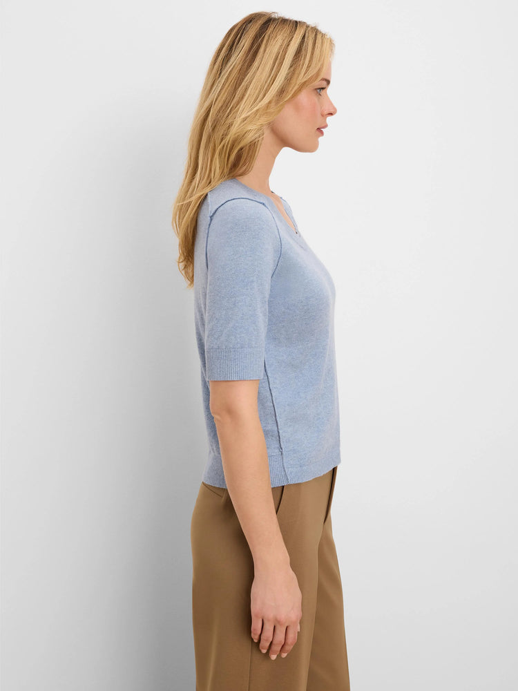 Light blue V-neck, elbow sleeves, exposed shoulder/side seams, and ribbed edges.