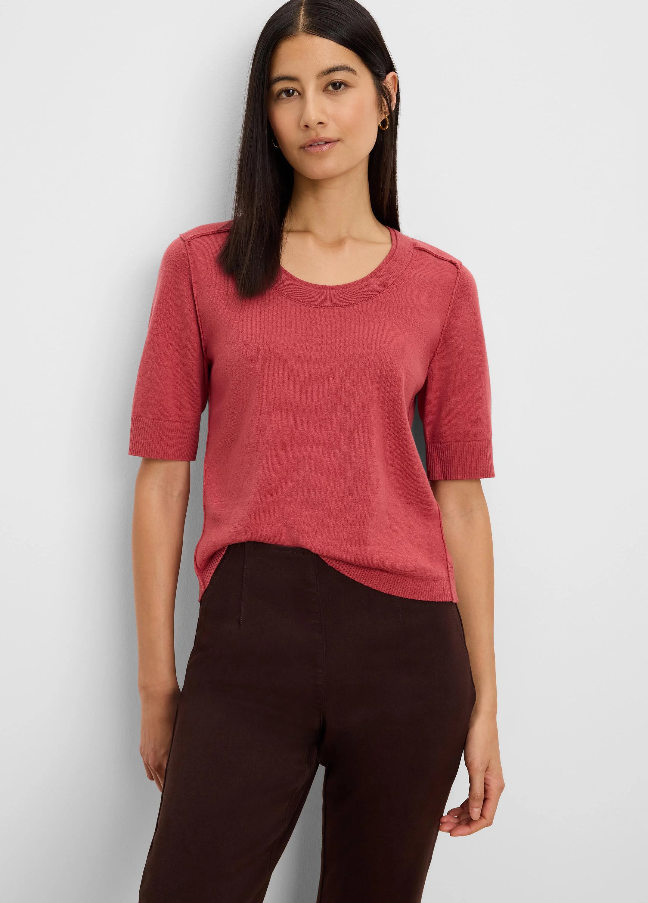 Terra cotta short-sleeve sweater tee with a crew neck, ribbed cuffs, hem, and subtle shoulder tabs, worn by a model.