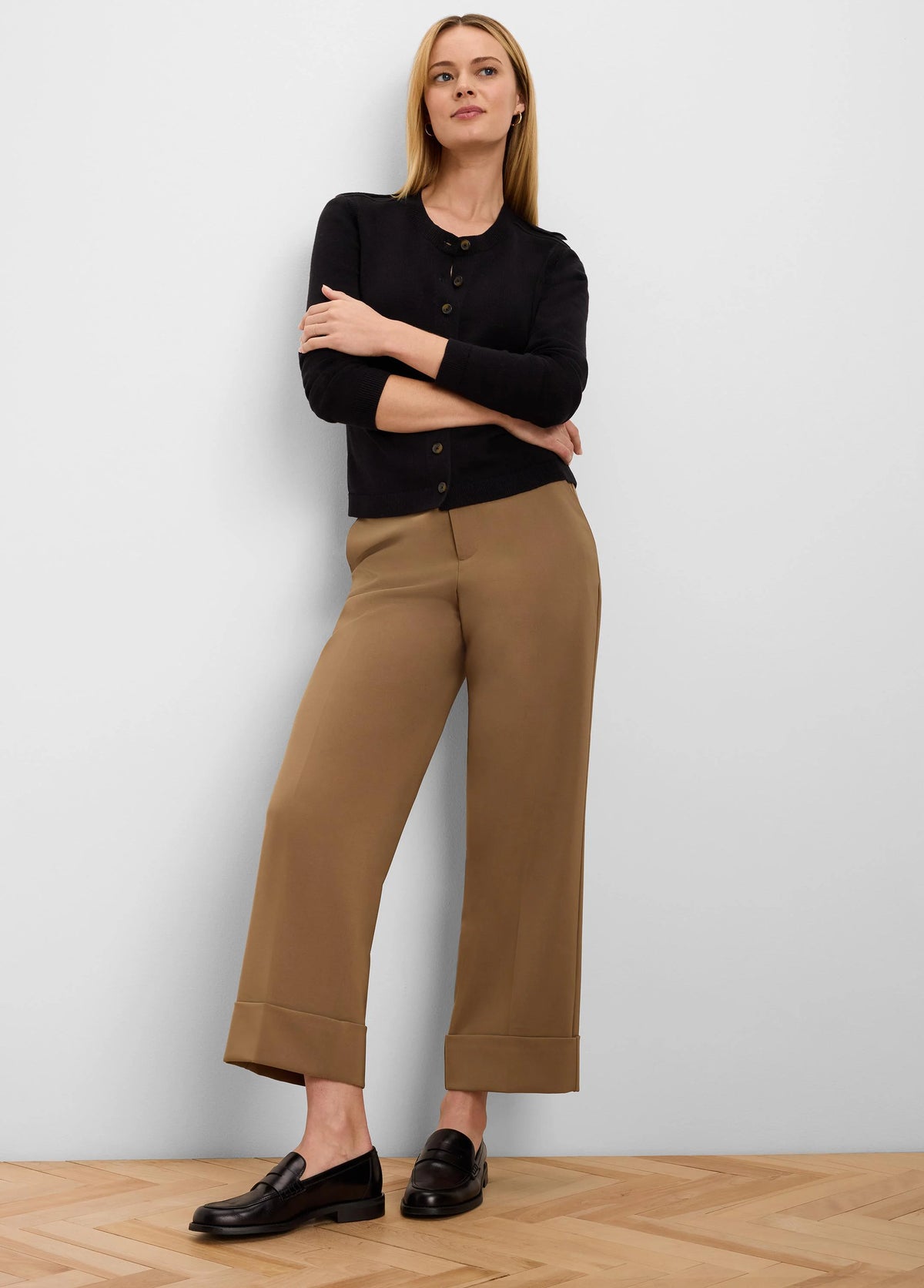 Black button-up cardigan with brown buttons. Features 3/4 length ribbed sleeves.