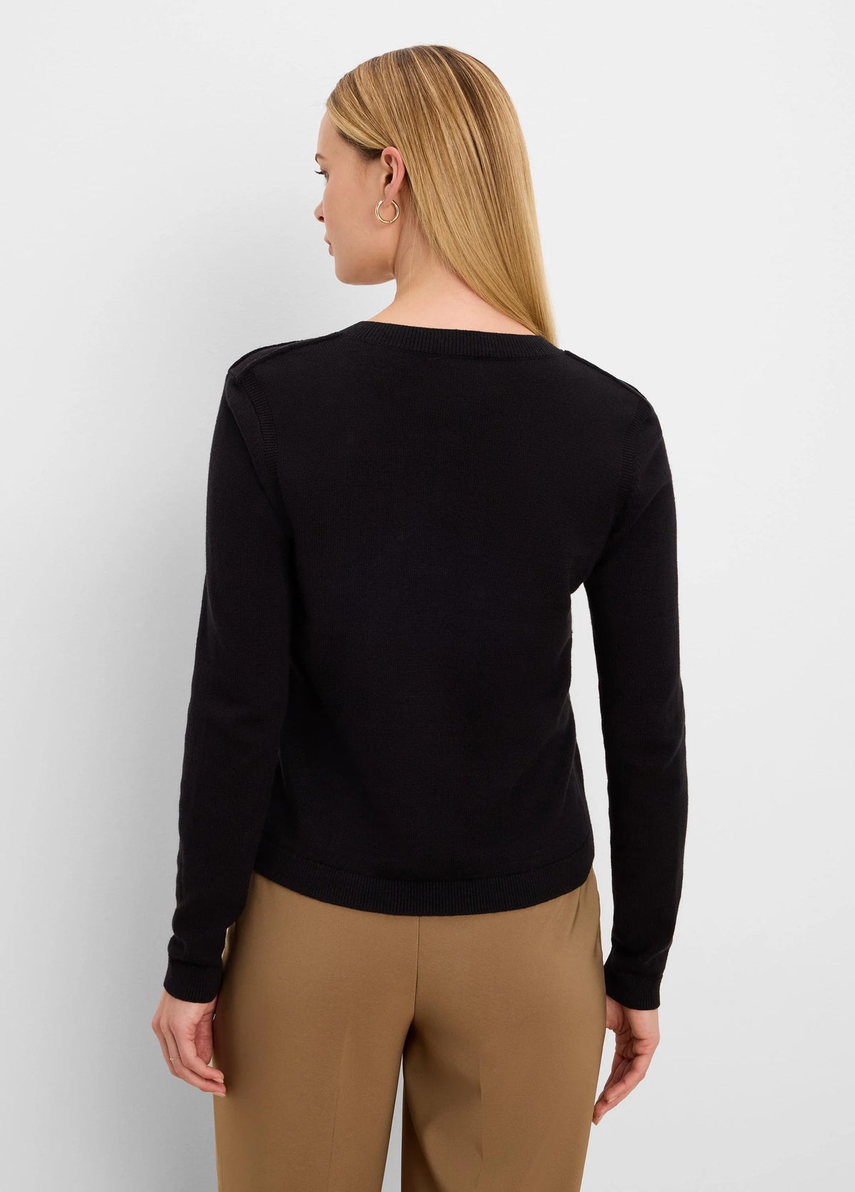 Black long-sleeve knit cardigan on model, viewed from back. Ribbed neckline, cuffs, and hem.