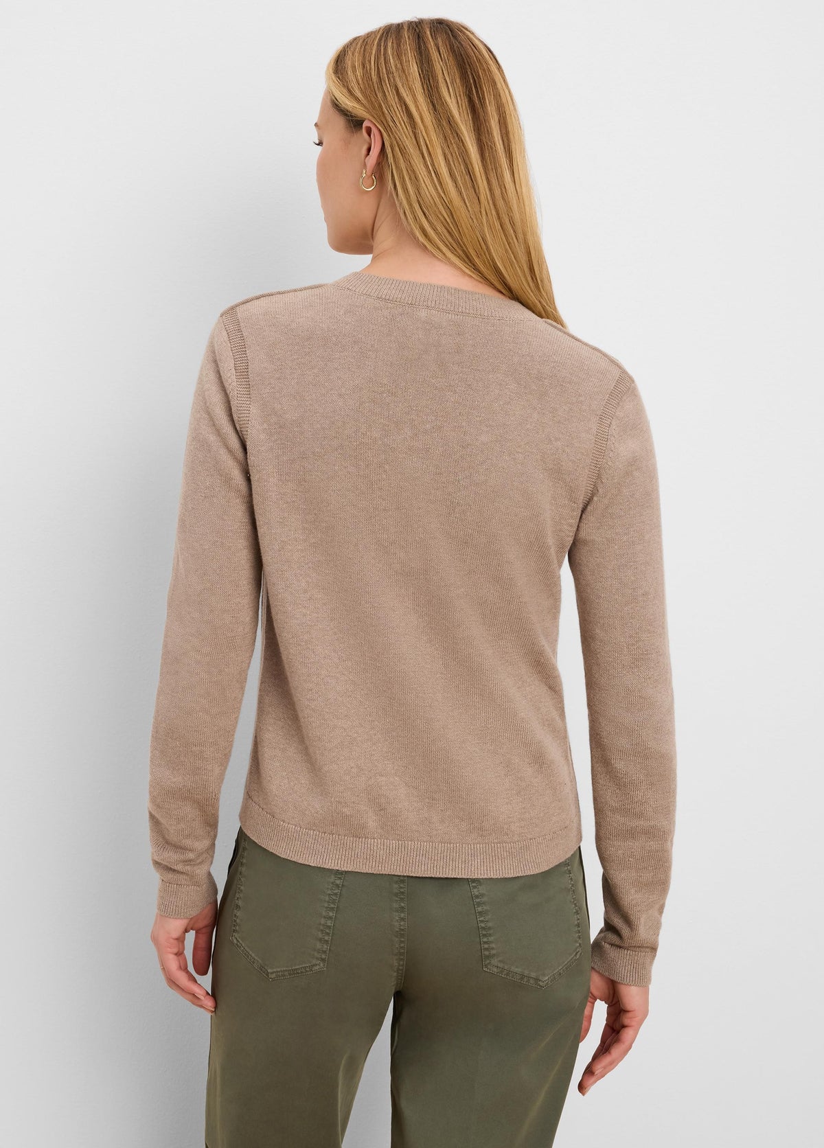 Back of a woman in a beige fine-knit cardigan. Features long sleeves, a ribbed hem, and neckline.