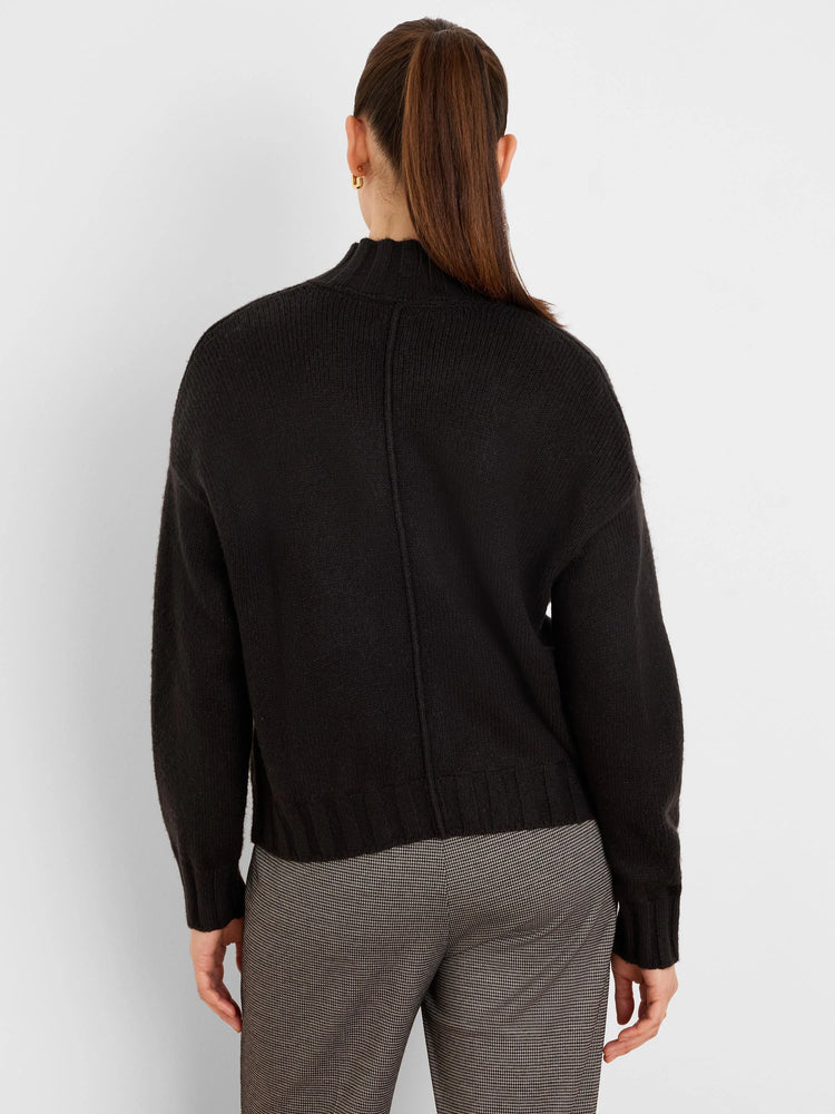 Black mock neck cardigan, back view. Loose fit with ribbed cuffs, hem, and a vertical back seam.