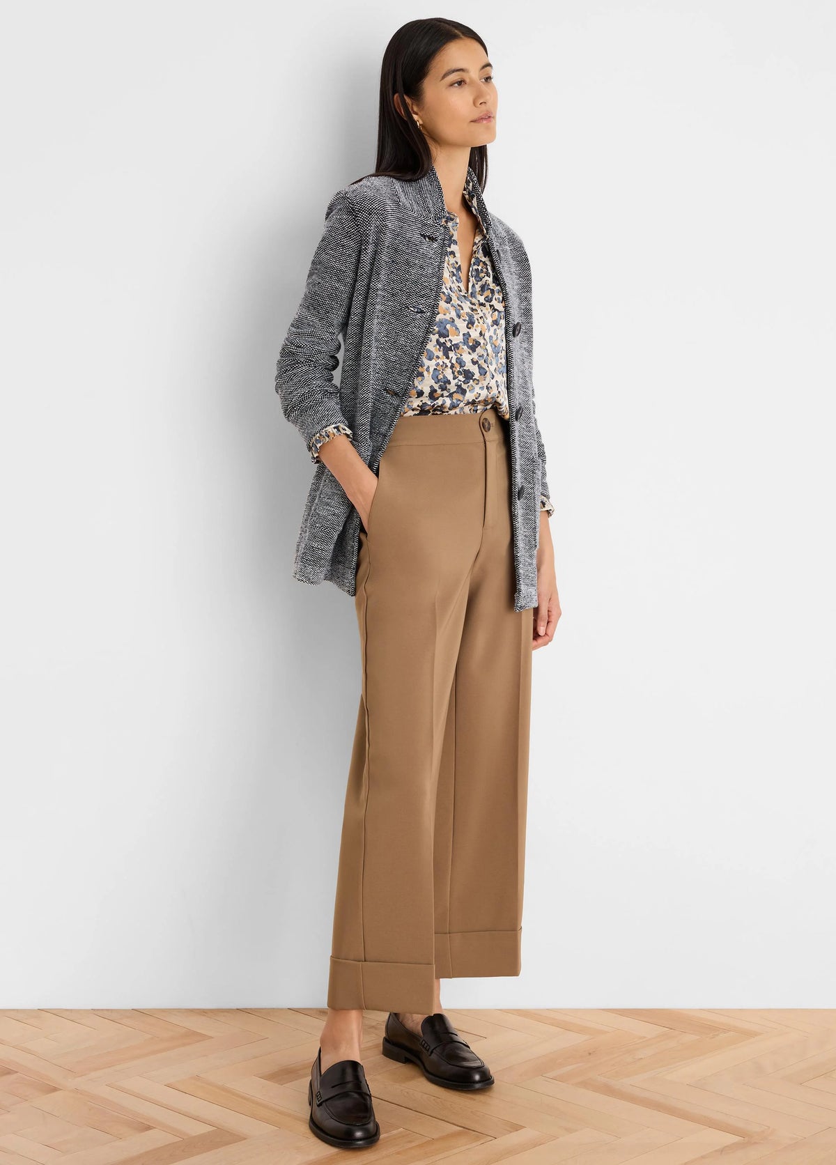 Black and white tweed stitch sweater jacket, textured, with dark buttons and a stand collar.