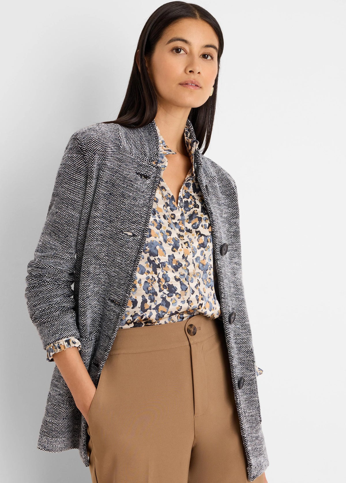 Speckled black & white tweed sweater jacket with visible dark buttons.