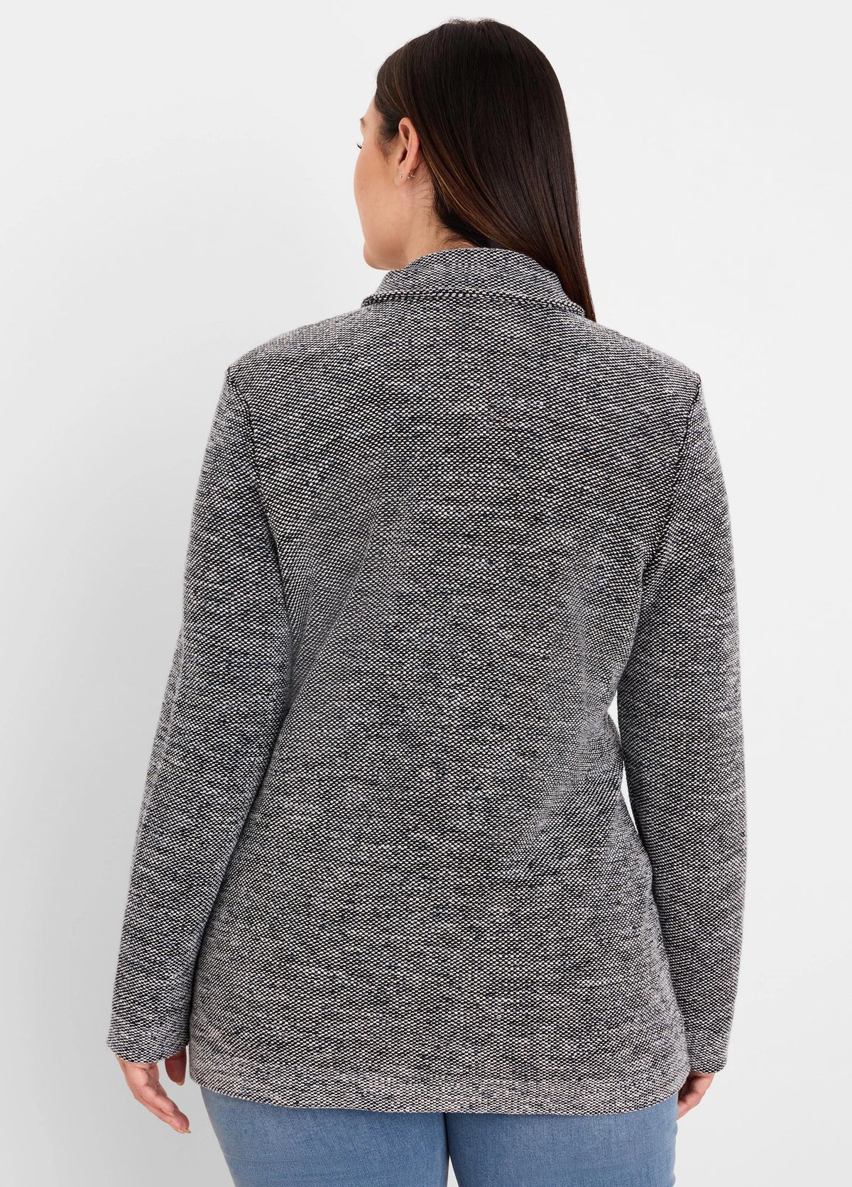Back of a collared black and white tweed sweater jacket with a textured, speckled pattern.