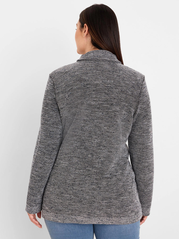 Back of a collared black and white tweed sweater jacket with a textured, speckled pattern.