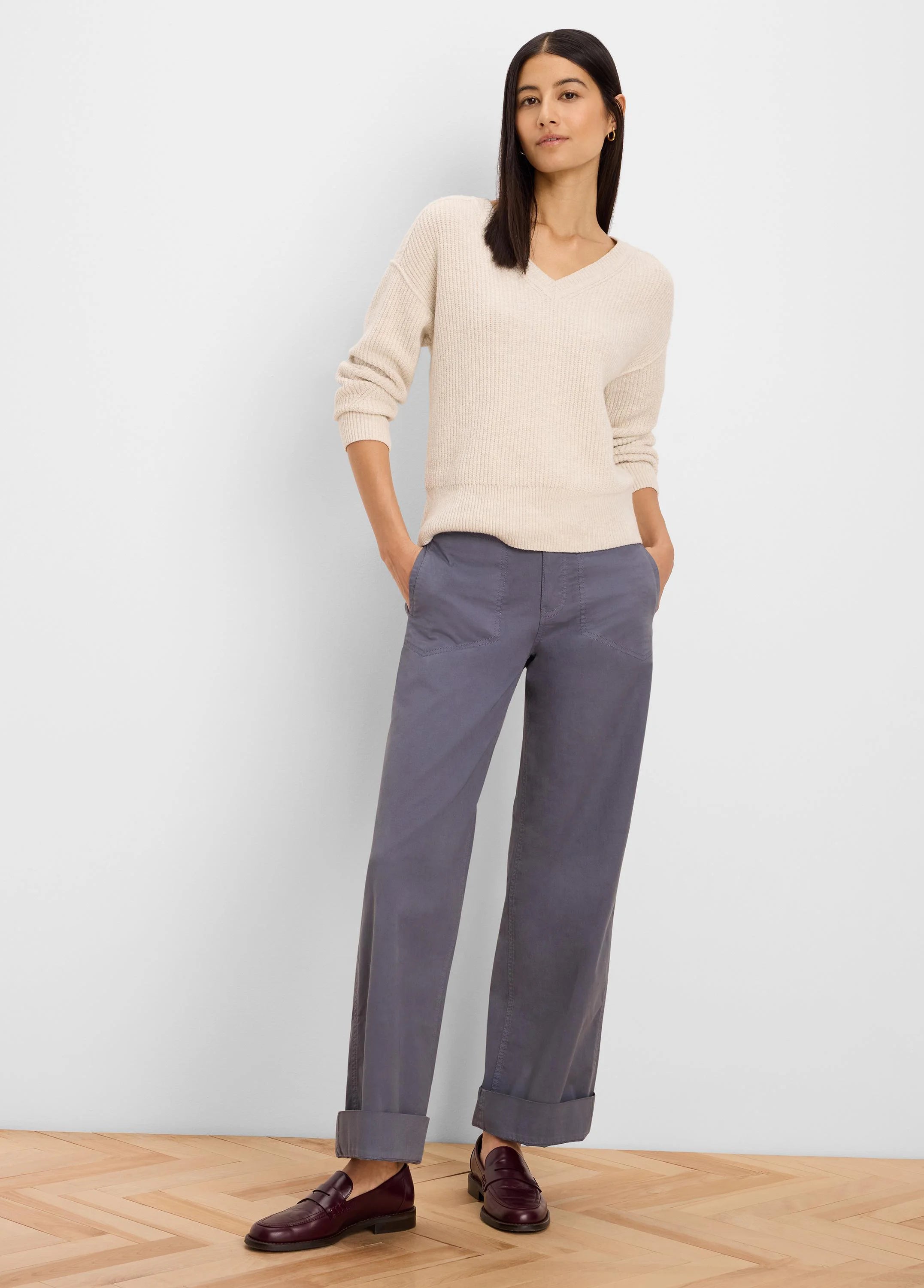 Light cream V-neck sweater with a ribbed knit texture and relaxed fit.