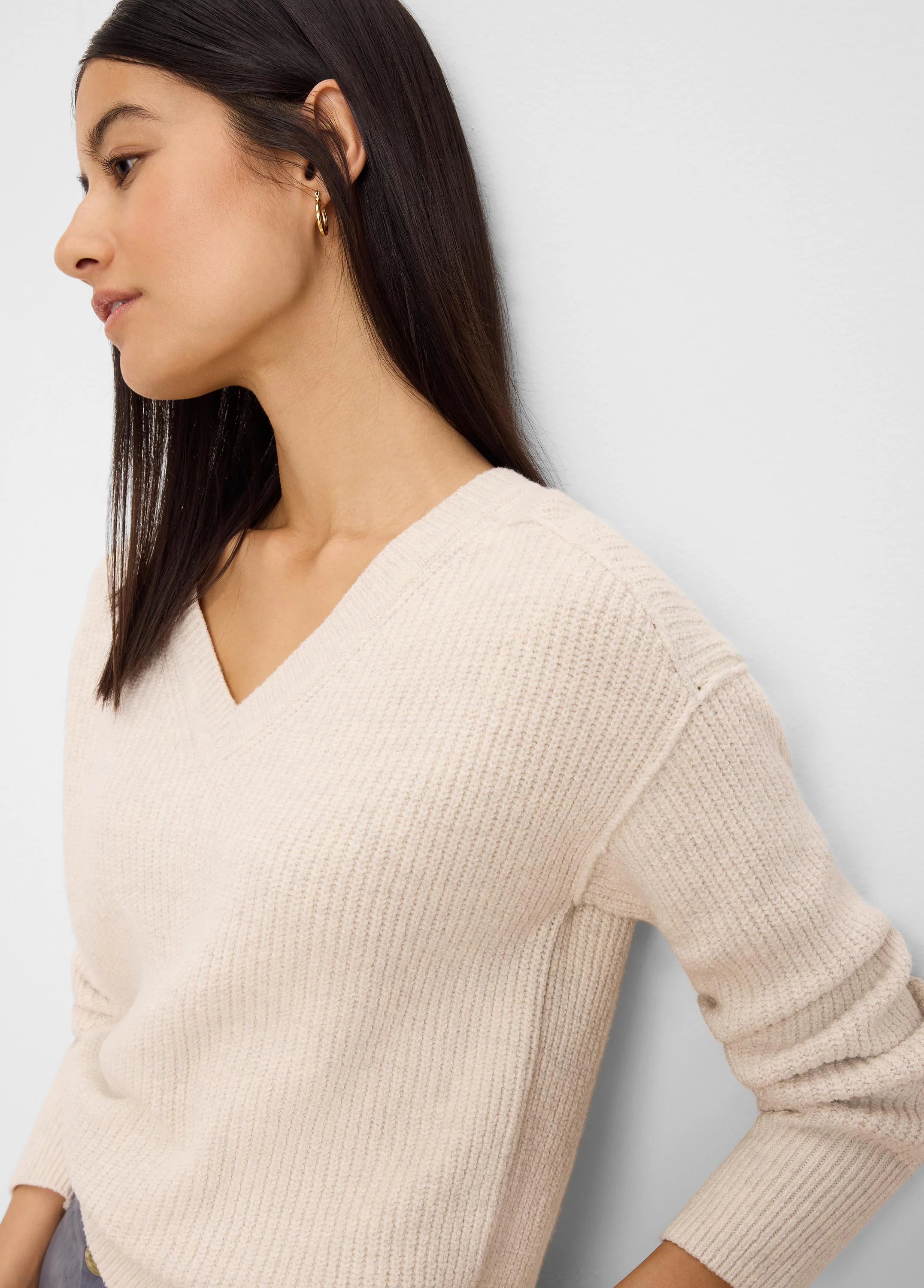 Oatmeal v-neck sweater with a thick ribbed knit texture.